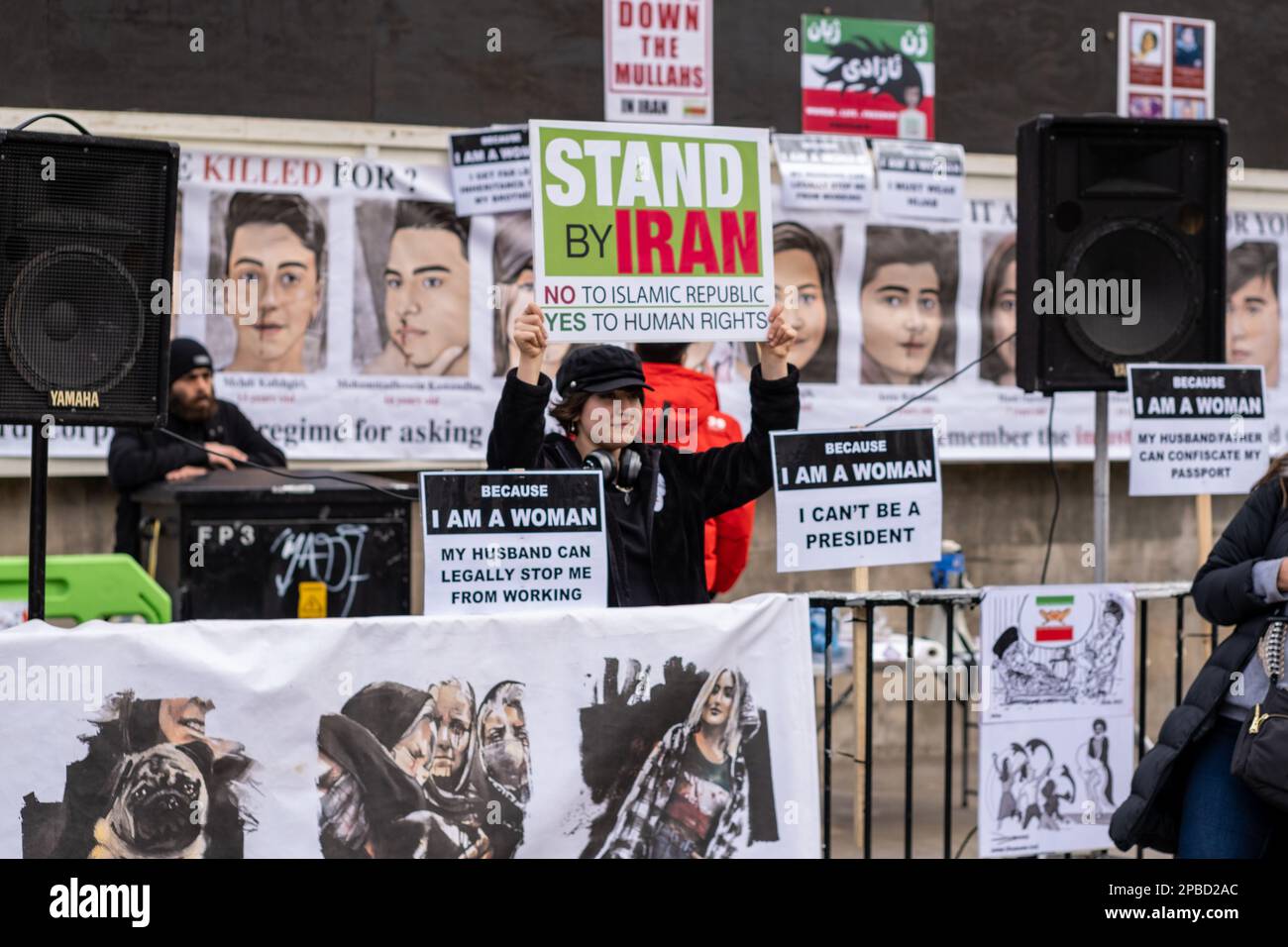 La donna tiene il cartello di protesta 'Stand by Iran' contro il regime iraniano, durante le proteste di Londra, marzo 2023. Foto Stock