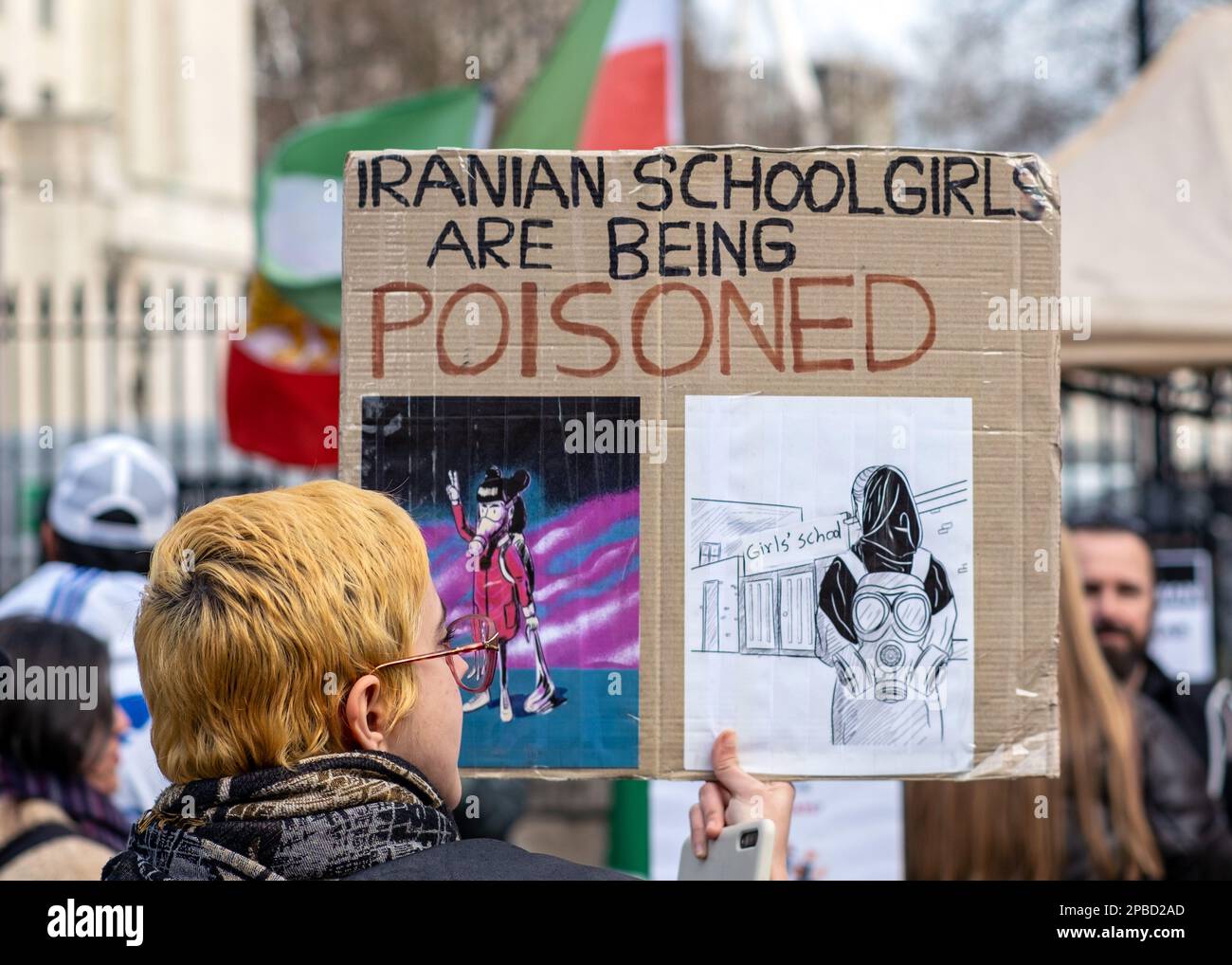 Un manifestante a Londra tiene un cartello che mette in evidenza che il regime iraniano sta avvelenando le studentesse, banner di protesta, 11th marzo 2023, Inghilterra, REGNO UNITO. Foto Stock
