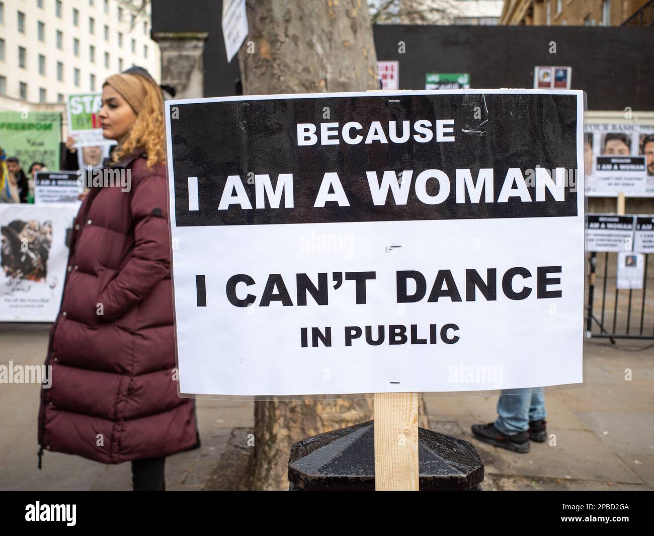 Protesta a Londra contro l'oppressivo regime iraniano, una donna si trova accanto a un cartello che recita: "Perché sono una donna, non posso ballare in pubblico”. Foto Stock