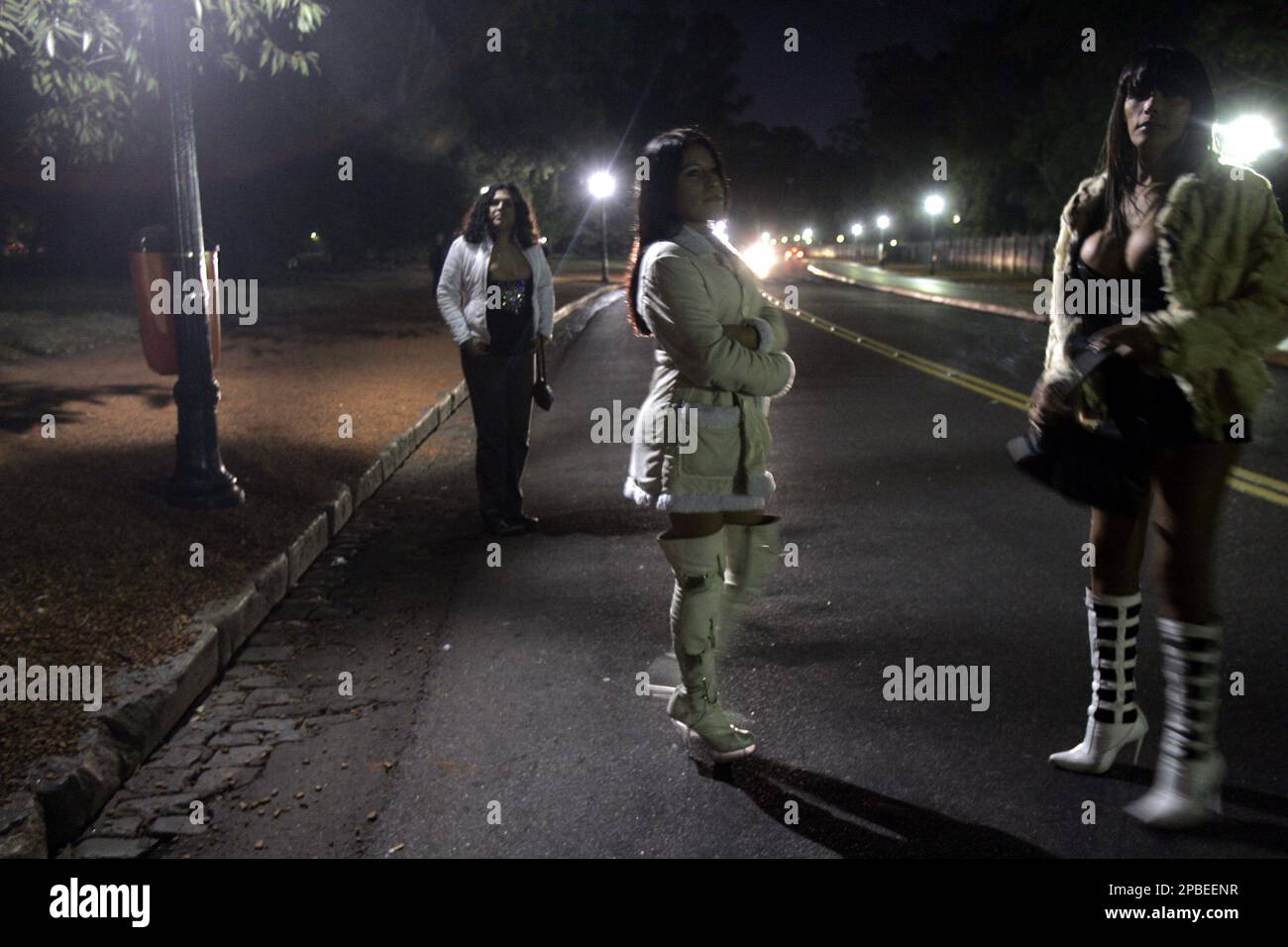 Transvestites stand on a street in Palermo park, 25 hectares of green space considered Buenos Aires's lungs, June 4, 2007. The park, used by citizens to enjoy nature and practice sports by day, turns into a busy location for prostitution at night. (AP Photo/Natacha Pisarenko) Foto Stock