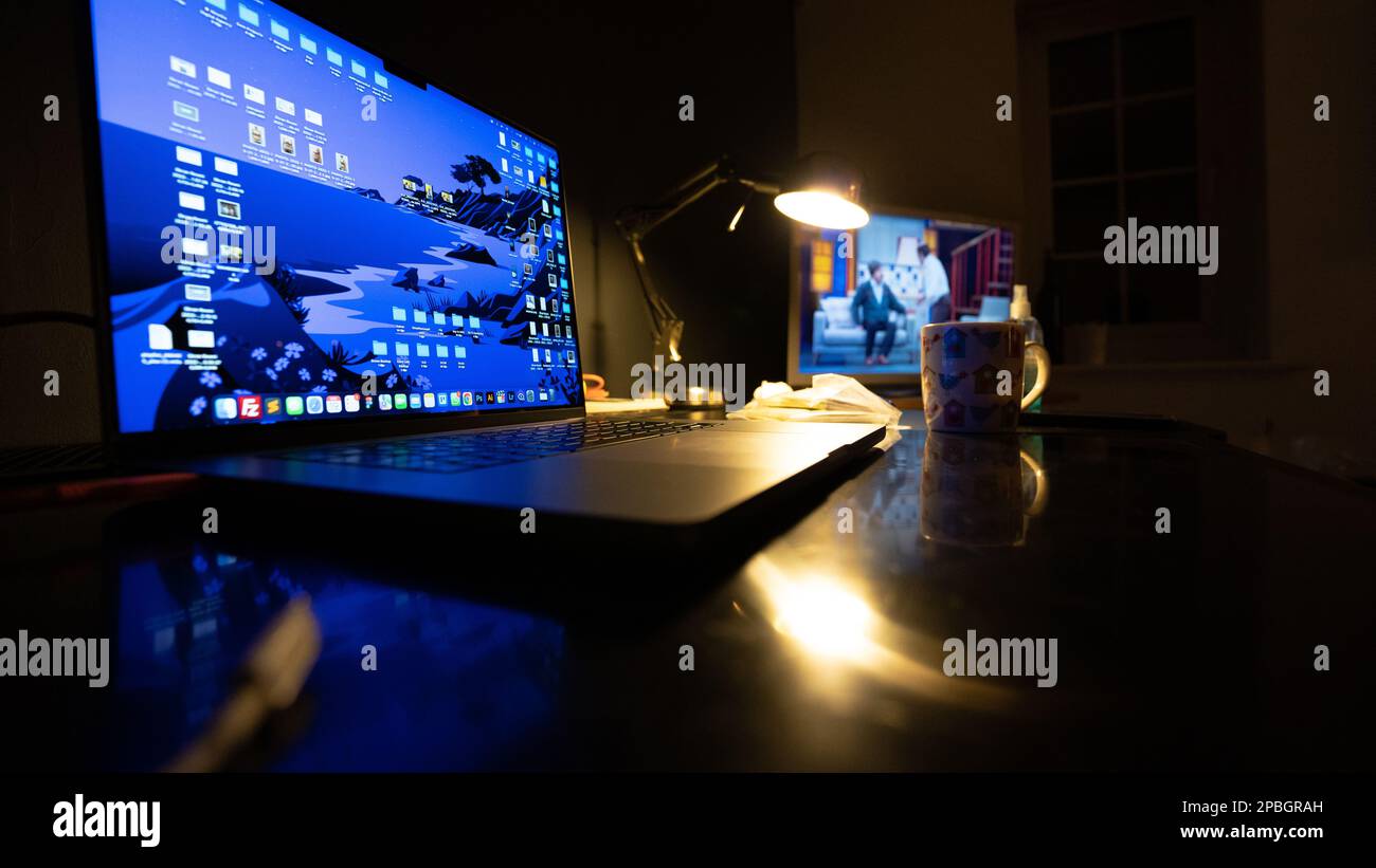 scrivania. Sul tavolo nero sono presenti un computer portatile e una lampada a soffitto. Foto Stock