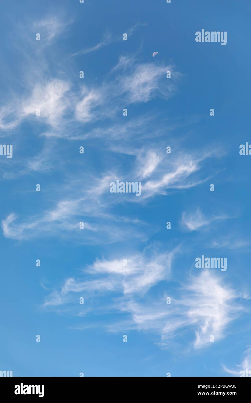 Nuvole e luna contro un bel cielo blu Foto Stock