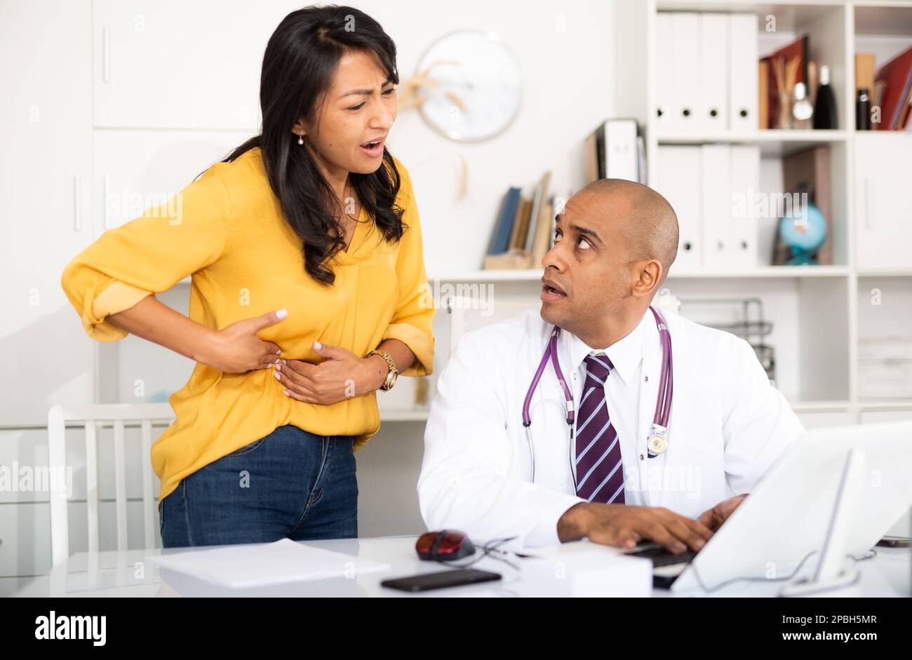 Il medico esamina il paziente con dolore acuto Foto Stock