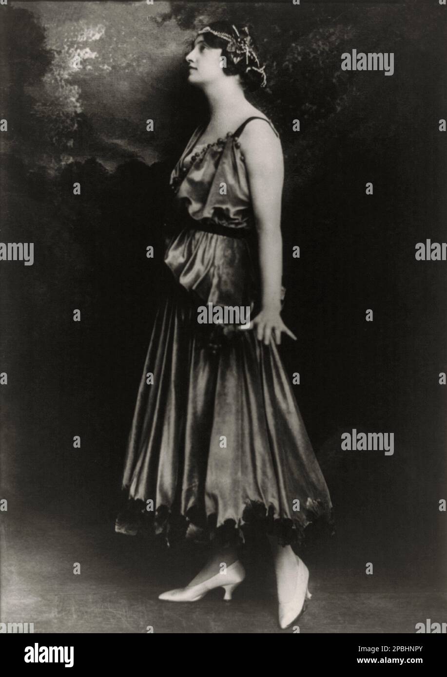 1915 , Parigi , FRANCIA : abito di moda femminile Bacchante di JEANNE PAQUIN ( 1869 - 1936 ) . Foto di Philippe Ortiz . Nato a Saint-Denis nel 1869, Paquin si è allenato come comò a Rouff e in seguito ha aperto la propria casa di moda nel 1891, la prima donna a farlo. La Maison Paquin divenne presto nota per i suoi abiti da sera pastello ispirati al XVIII secolo e gli abiti da giorno su misura, nonché per le sue numerose acrobazie pubblicitarie, tra cui l'organizzazione di sfilate di moda per promuovere i suoi nuovi modelli e l'invio dei suoi modelli a opere e gare per mostrare i suoi disegni. Anche Paquin spesso co Foto Stock