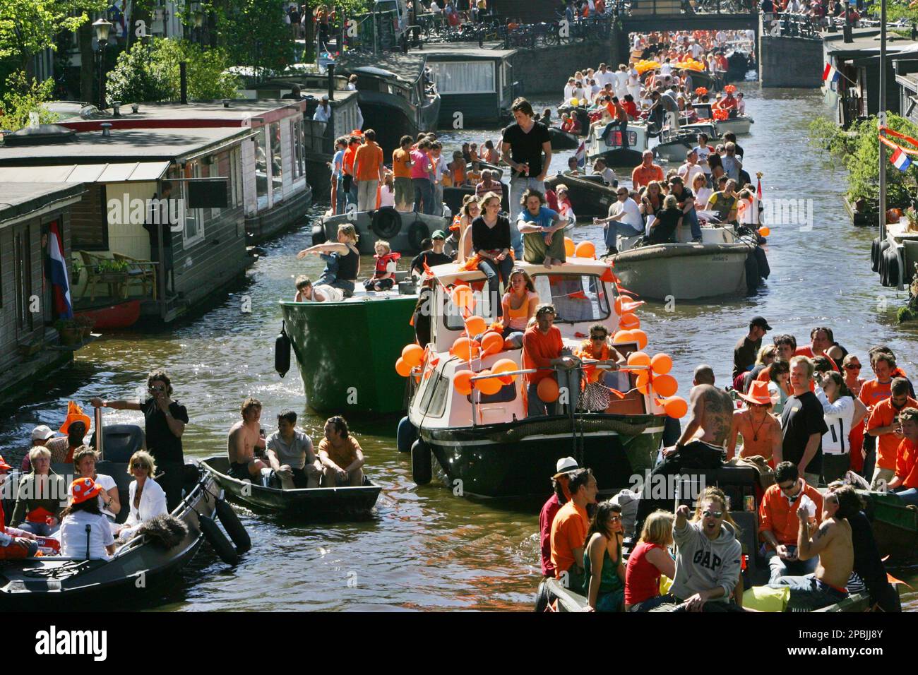 People on boats celebrate Queen's Day in the center of Amsterdam, Netherlands, Monday April 30, 2007. The birthday of the late Queen Mother is a national holiday in the Netherlands, many people dress in orange colors referring to the royal family House of Orange. (AP Photo/Peter Dejong) Foto Stock