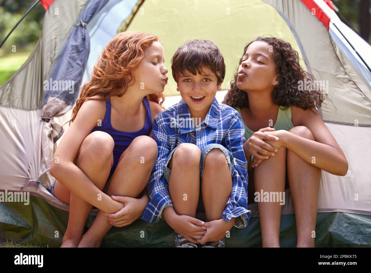 Che ragazzo fortunato. Ripresa di un gruppo di amici in una tenda mentre si accampano. Foto Stock