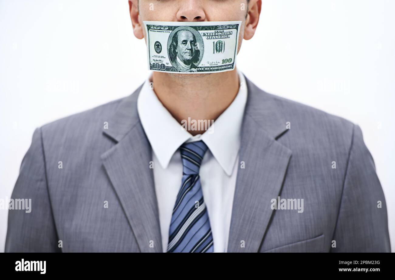 Mantenga esso quiet o else... colpo di concetto di un uomo d'affari con i soldi che coprono la sua bocca. Foto Stock