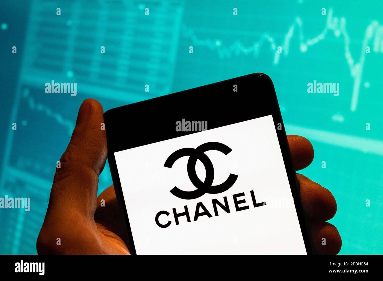 Cina. 15th Feb, 2023. In questa foto, il logo Chanel del marchio cosmetico multinazionale Fench è visualizzato su uno smartphone con un grafico dell'indice della borsa economica sullo sfondo. (Credit Image: © Budrul Chukrut/SOPA Images via ZUMA Press Wire) SOLO PER USO EDITORIALE! Non per USO commerciale! Foto Stock
