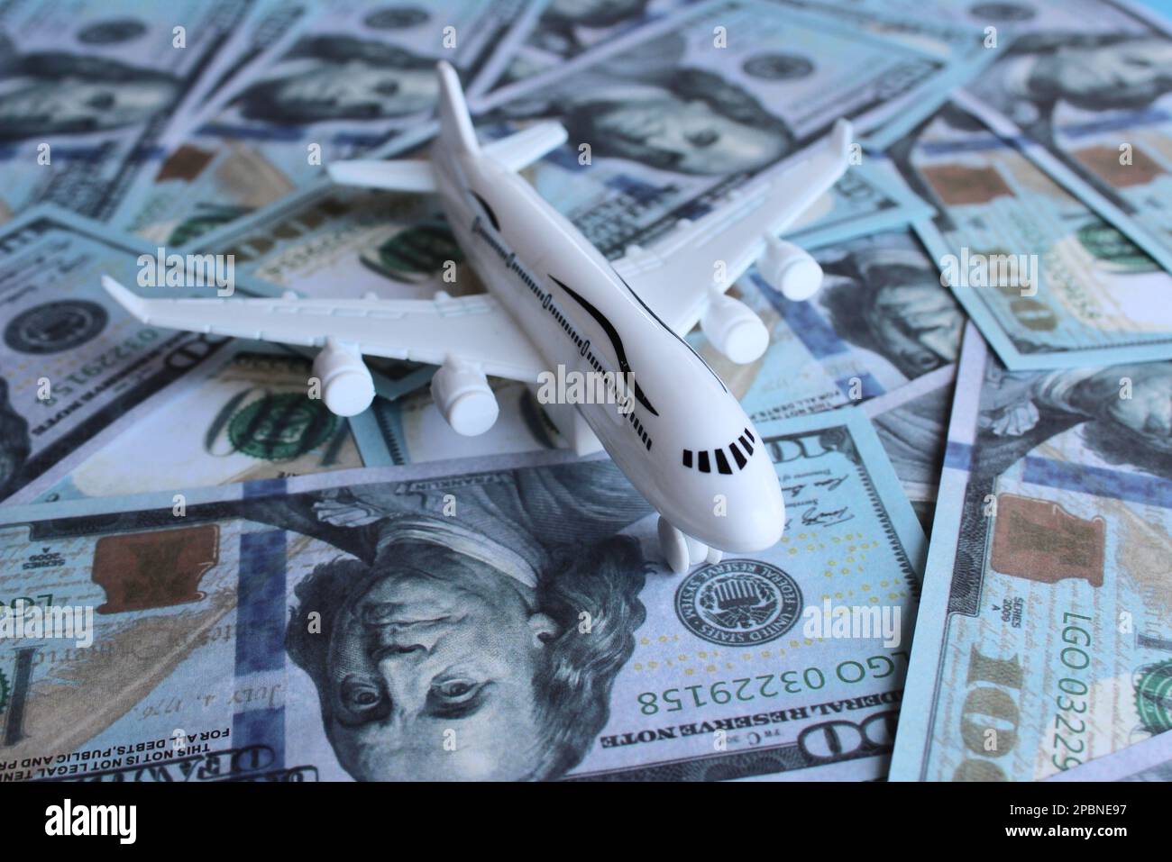 Immagine di messa a fuoco selettiva di aereo giocattolo e denaro. Concetto di industria dei trasporti e dell'aviazione Foto Stock