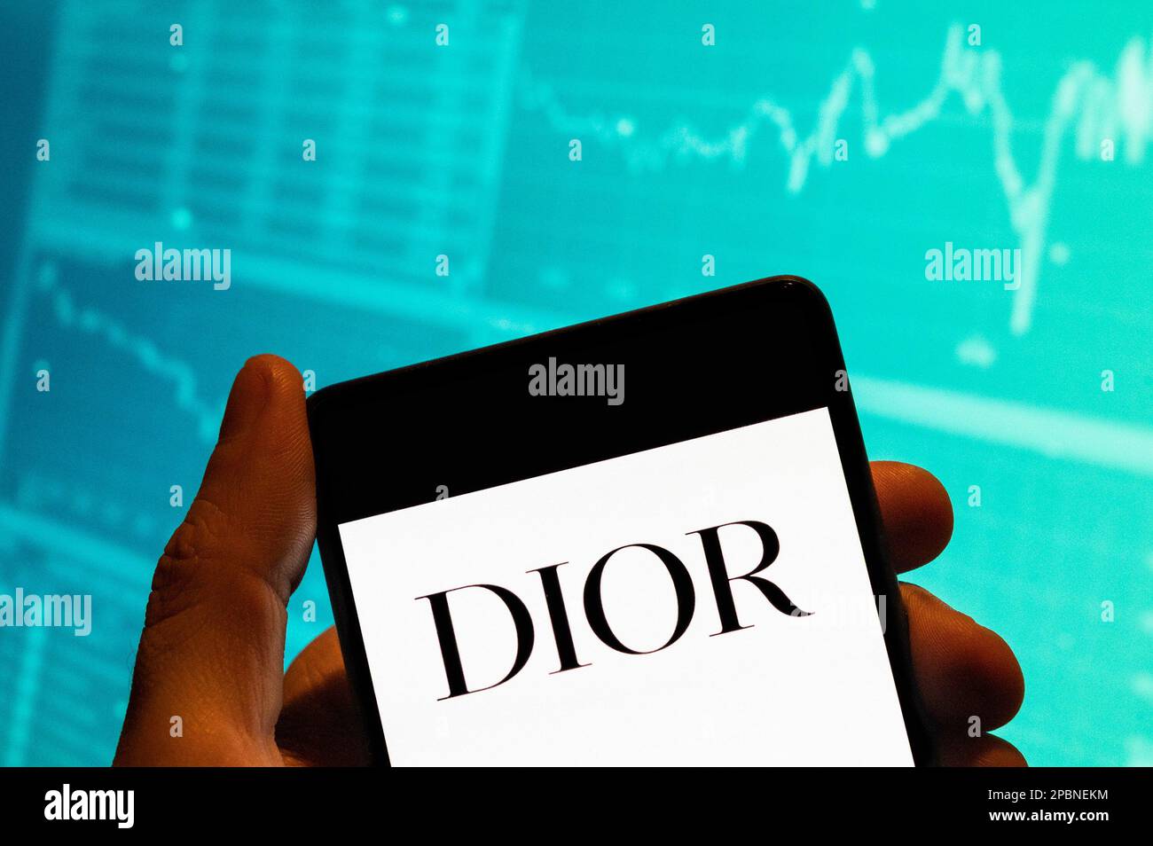 Cina. 15th Feb, 2023. In questa illustrazione, i beni di lusso francesi, come l'abbigliamento e i prodotti di bellezza marchio Christian Dior logo è visto su uno smartphone con un grafico di indice di borsa economica in background. (Credit Image: © Budrul Chukrut/SOPA Images via ZUMA Press Wire) SOLO PER USO EDITORIALE! Non per USO commerciale! Foto Stock