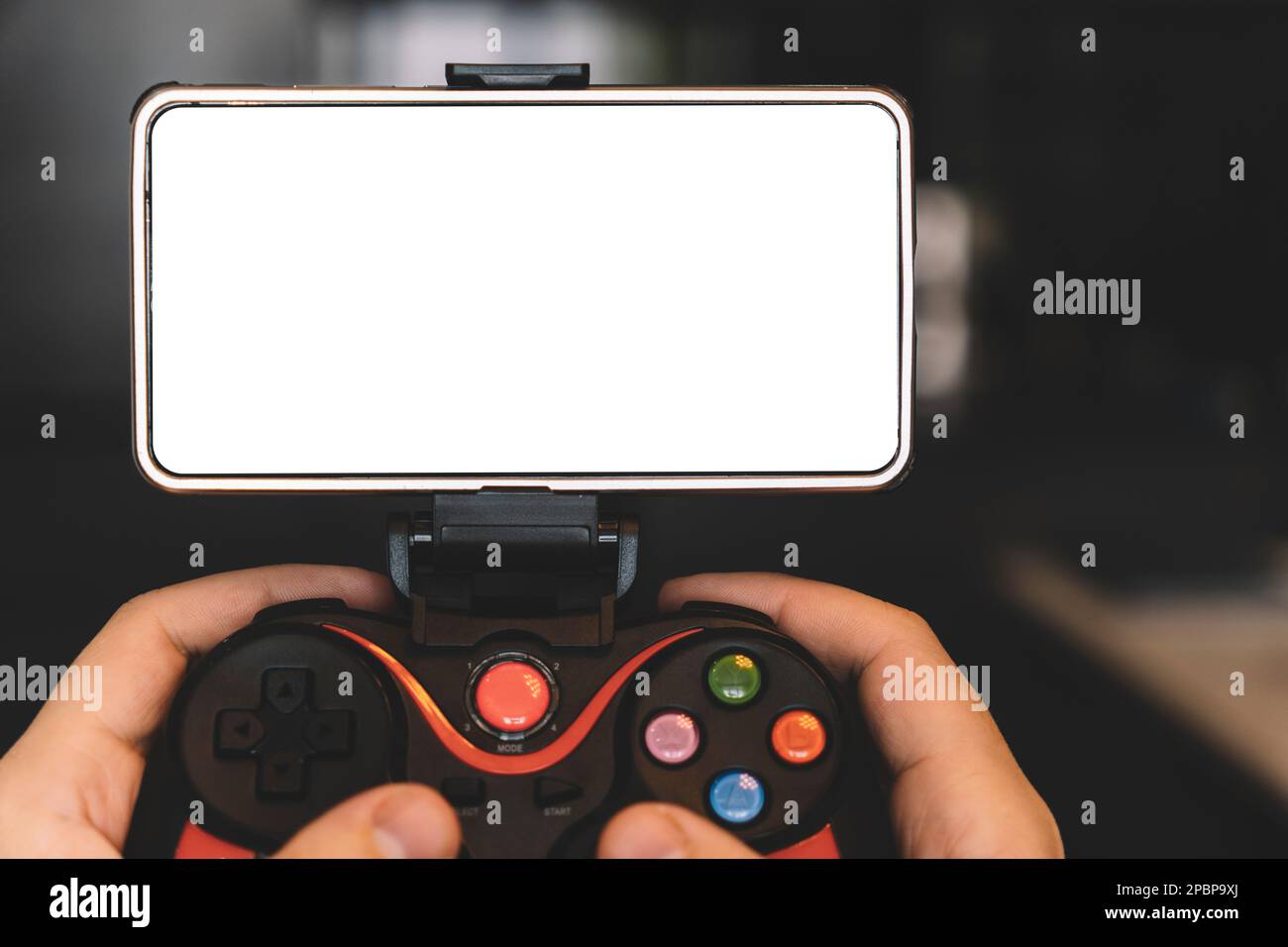 Game Pad con smartphone in mani su sfondo nero. Concetto di gaming mobile. una schermata bianca vuota su uno smartphone. spazio di copia. Foto Stock