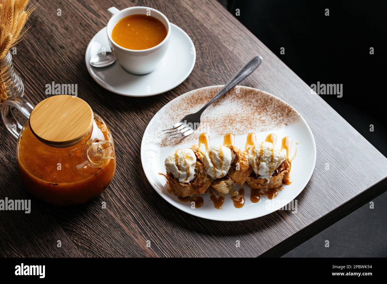 torta di mele con palle di gelato, tè in una teiera Foto Stock