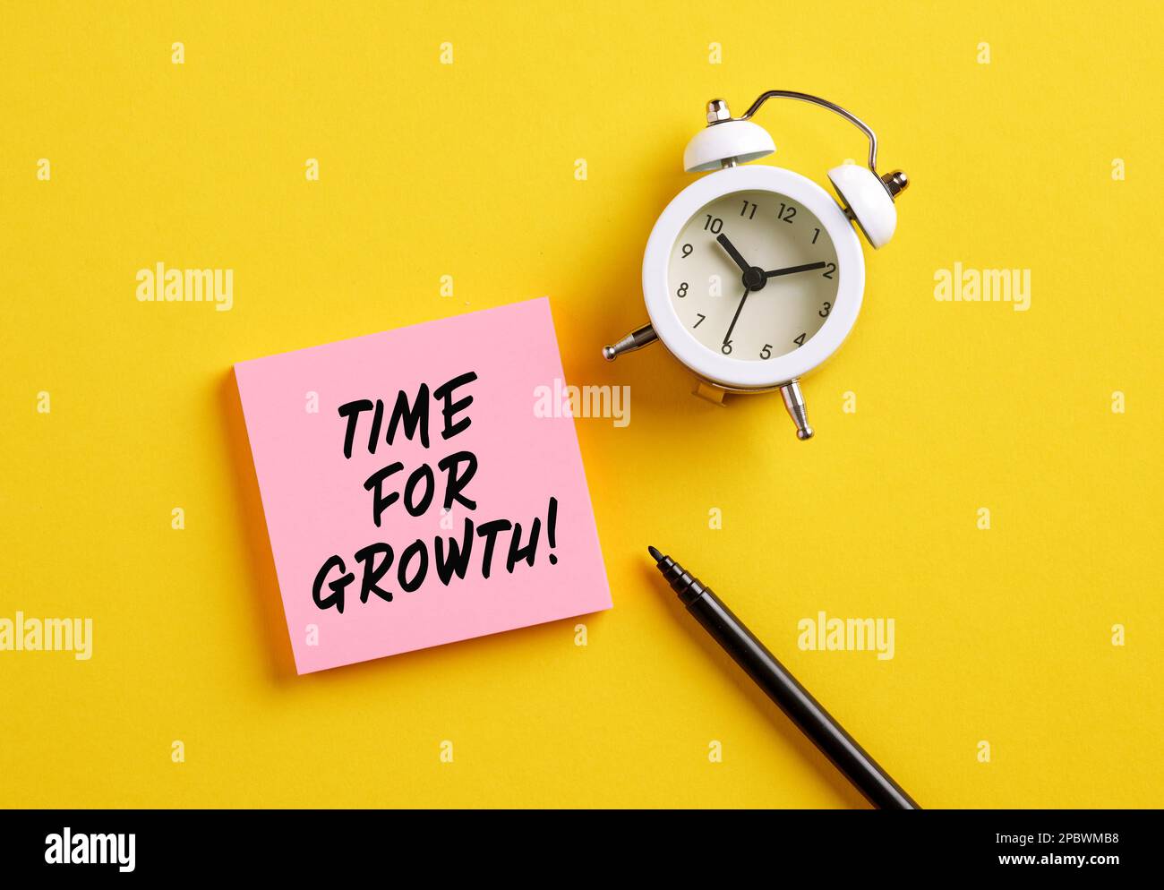 Tempistica per il concetto di crescita aziendale. Il tempo di parola per la crescita su carta da appunti rosa con sveglia e penna. Foto Stock