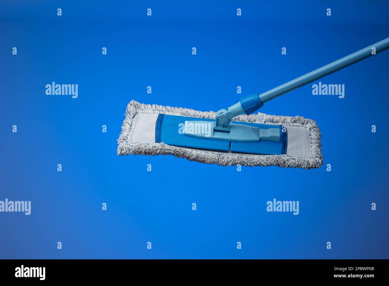 Spazzolone generico in plastica con spugna tessile sporca. Primo piano ripresa in studio, isolata su sfondo blu. Foto Stock