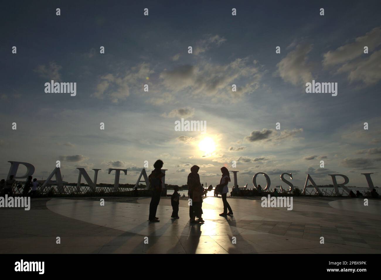 I cittadini e i turisti hanno un pomeriggio libero presso la piattaforma ricreativa della spiaggia di Losari nella zona costiera di Makassar City, Sulawesi Sud, Indonesia. Una delle 30 città costiere dell'Indonesia che si stima sia potenzialmente colpita dall'aumento del livello del mare, Makassar è stata considerata dai ricercatori e dagli scienziati una città con notevoli problemi ambientali e sociali; principalmente come risultato della condizione geomorfologica e della politica di utilizzo del territorio e di sviluppo costiero, in particolare i progetti di bonifica attualmente condotti dai governi provinciali. Foto Stock