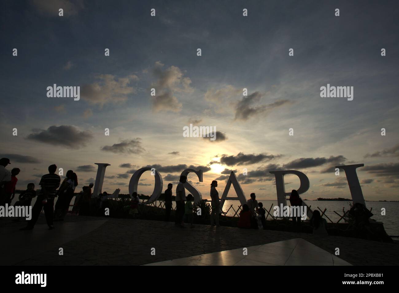 I cittadini e i turisti hanno un pomeriggio libero presso la piattaforma ricreativa della spiaggia di Losari nella zona costiera di Makassar City, Sulawesi Sud, Indonesia. Una delle 30 città costiere dell'Indonesia che si stima sia potenzialmente colpita dall'aumento del livello del mare, Makassar è stata considerata dai ricercatori e dagli scienziati una città con notevoli problemi ambientali e sociali; principalmente come risultato della condizione geomorfologica e della politica di utilizzo del territorio e di sviluppo costiero, in particolare i progetti di bonifica attualmente condotti dai governi provinciali. Foto Stock