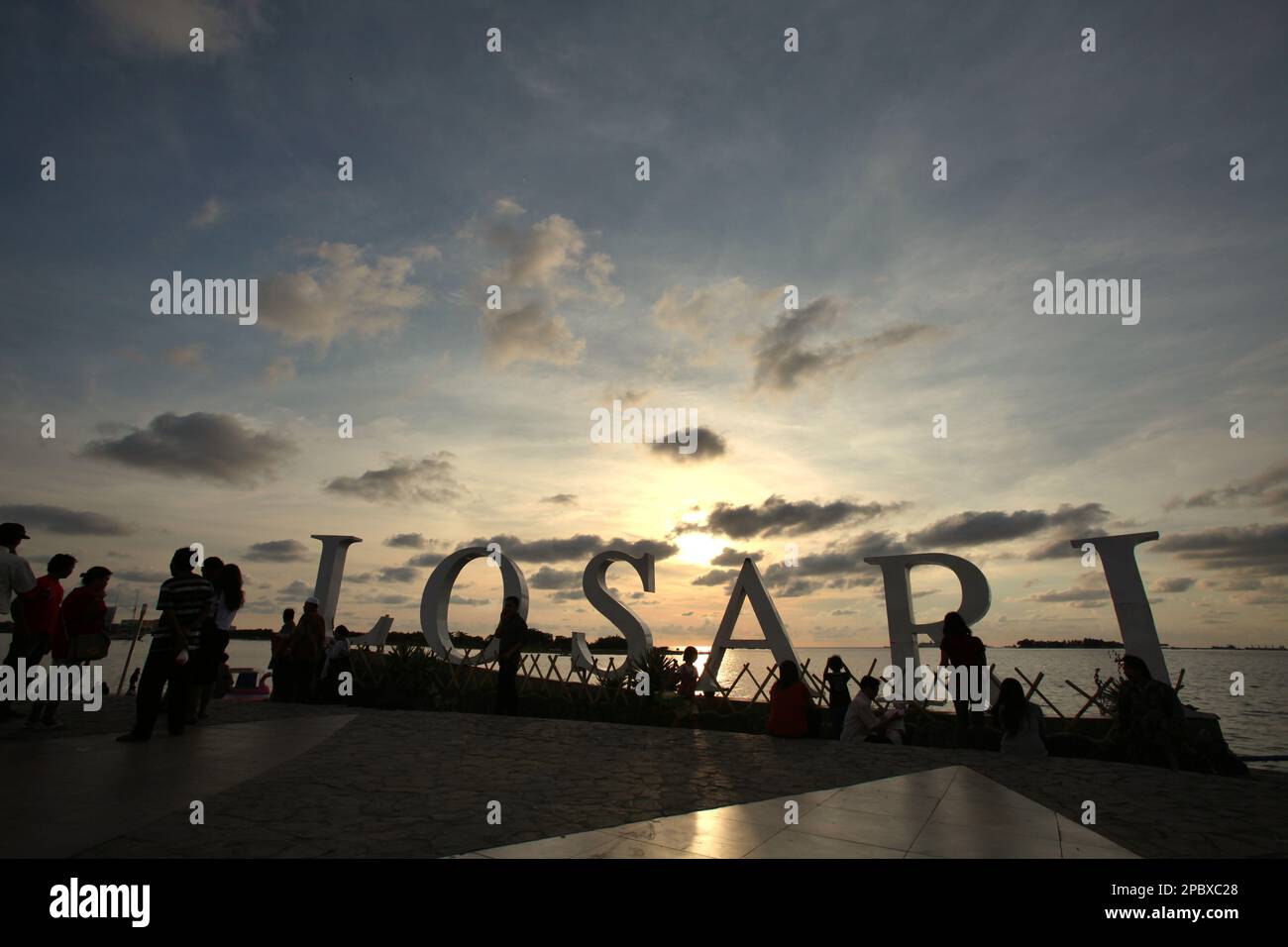 I cittadini e i turisti hanno un pomeriggio libero presso la piattaforma ricreativa della spiaggia di Losari nella zona costiera di Makassar City, Sulawesi Sud, Indonesia. Una delle 30 città costiere dell'Indonesia che si stima sia potenzialmente colpita dall'aumento del livello del mare, Makassar è stata considerata dai ricercatori e dagli scienziati una città con notevoli problemi ambientali e sociali; principalmente come risultato della condizione geomorfologica e della politica di utilizzo del territorio e di sviluppo costiero, in particolare i progetti di bonifica attualmente condotti dai governi provinciali. Foto Stock