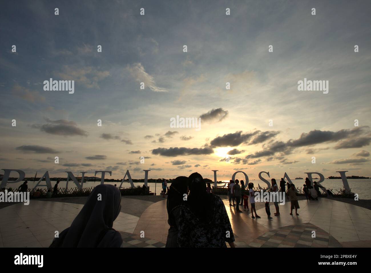 I cittadini e i turisti hanno un pomeriggio libero presso la piattaforma ricreativa della spiaggia di Losari nella zona costiera di Makassar City, Sulawesi Sud, Indonesia. Una delle 30 città costiere dell'Indonesia che si stima sia potenzialmente colpita dall'aumento del livello del mare, Makassar è stata considerata dai ricercatori e dagli scienziati una città con notevoli problemi ambientali e sociali; principalmente come risultato della condizione geomorfologica e della politica di utilizzo del territorio e di sviluppo costiero, in particolare i progetti di bonifica attualmente condotti dai governi provinciali. Foto Stock