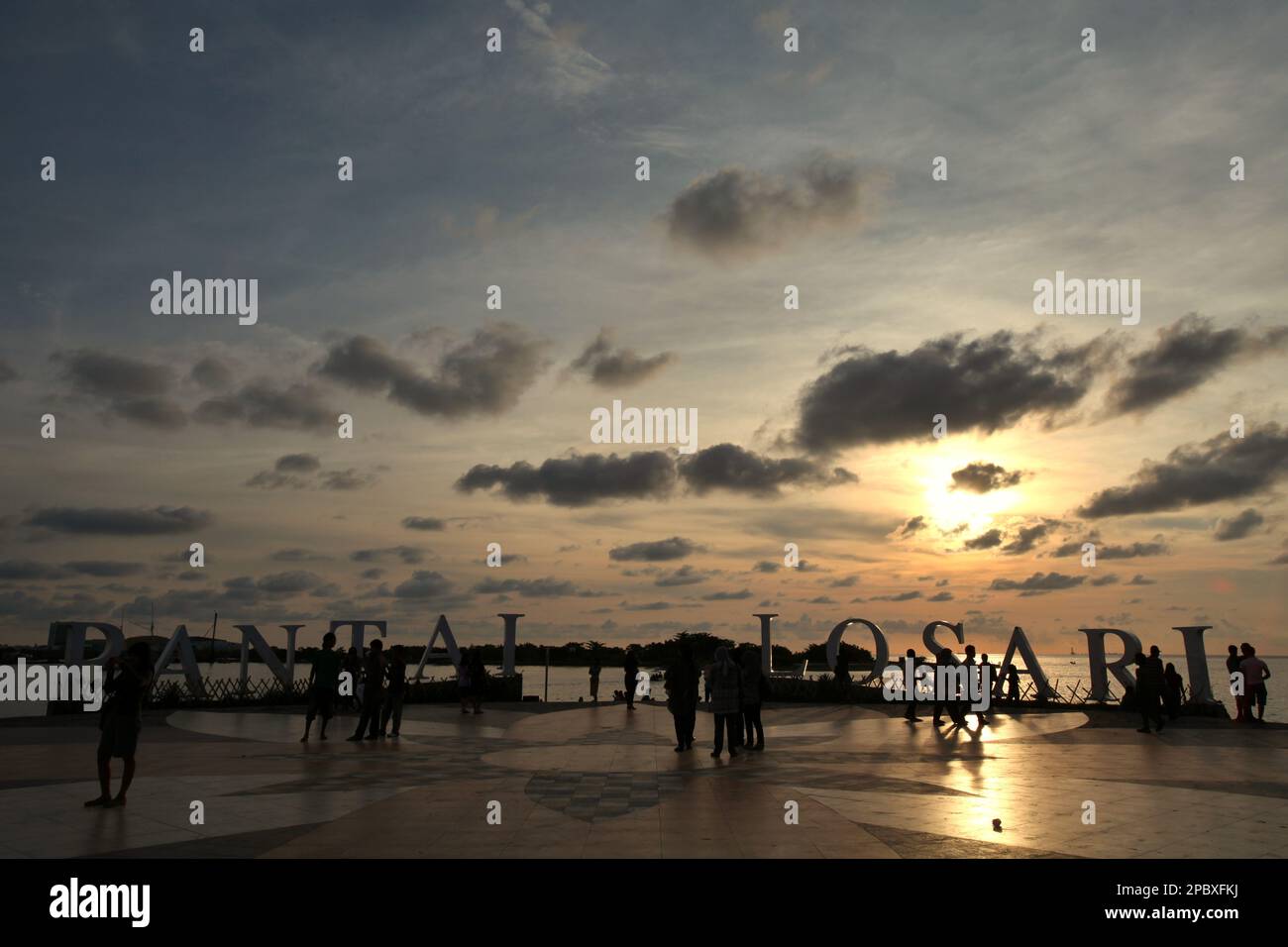 I cittadini e i turisti hanno un pomeriggio libero presso la piattaforma ricreativa della spiaggia di Losari nella zona costiera di Makassar City, Sulawesi Sud, Indonesia. Una delle 30 città costiere dell'Indonesia che si stima sia potenzialmente colpita dall'aumento del livello del mare, Makassar è stata considerata dai ricercatori e dagli scienziati una città con notevoli problemi ambientali e sociali; principalmente come risultato della condizione geomorfologica e della politica di utilizzo del territorio e di sviluppo costiero, in particolare i progetti di bonifica attualmente condotti dai governi provinciali. Foto Stock