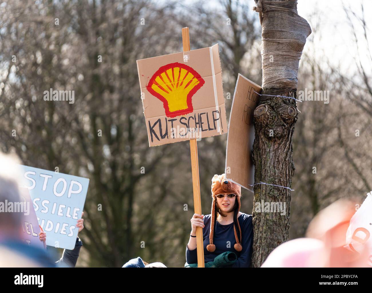 L'Aia, Paesi Bassi, 11.03.2023, giovane attivista durante la protesta del movimento di ribellione contro le estrazioni fossili. Banner con la shell Foto Stock