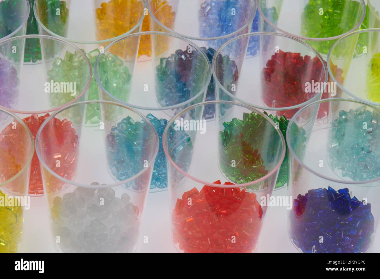 diversi granulati in resina plastica colorata trasparente in vetro per test in laboratorio. Massa per stampaggio ad iniezione e processo di estrusione Foto Stock