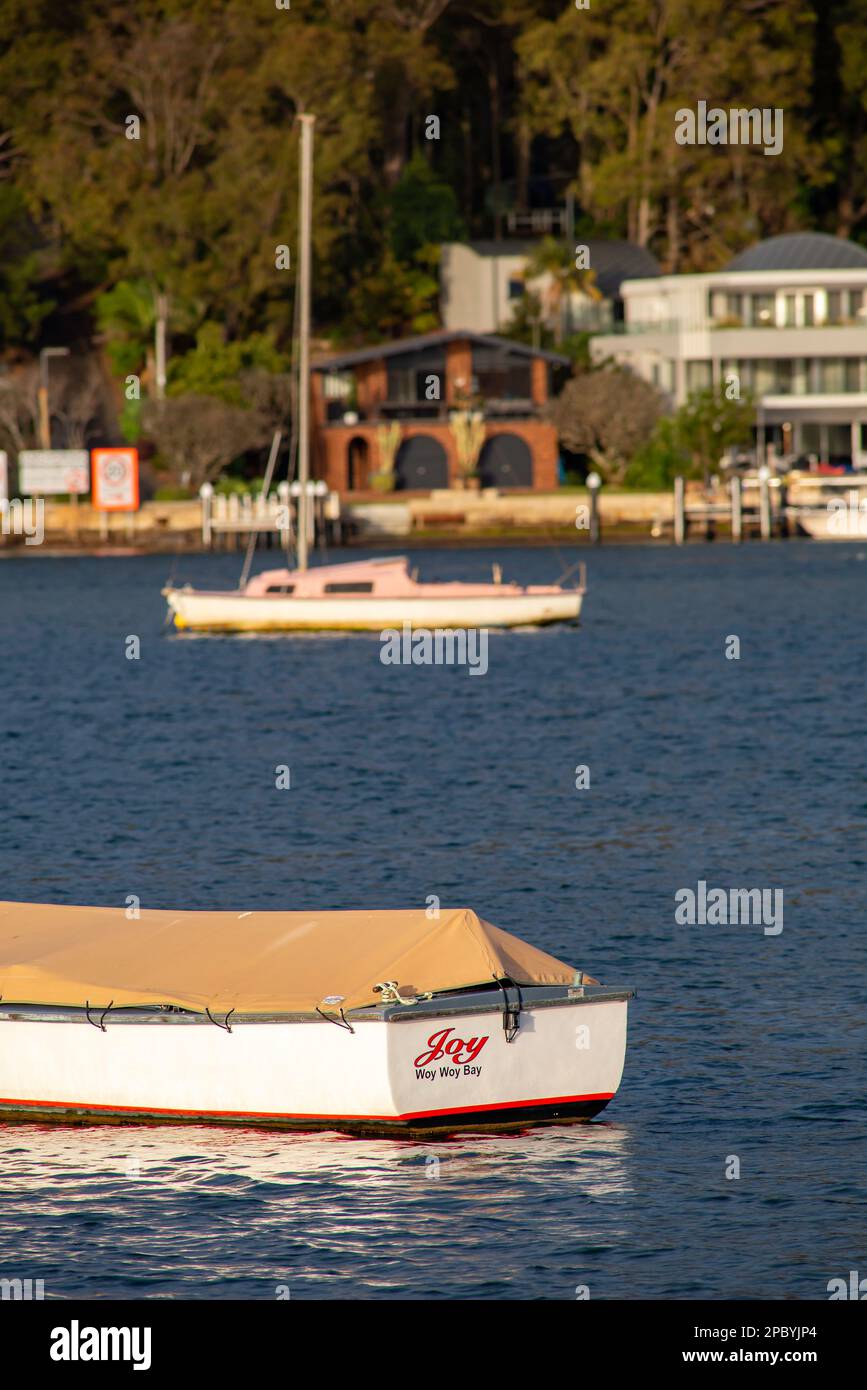 Le barche si sono legate al loro ormeggio nella calda luce del sole del mattino presto a Ettalong Beach sulla costa centrale del nuovo Galles del Sud in Australia Foto Stock
