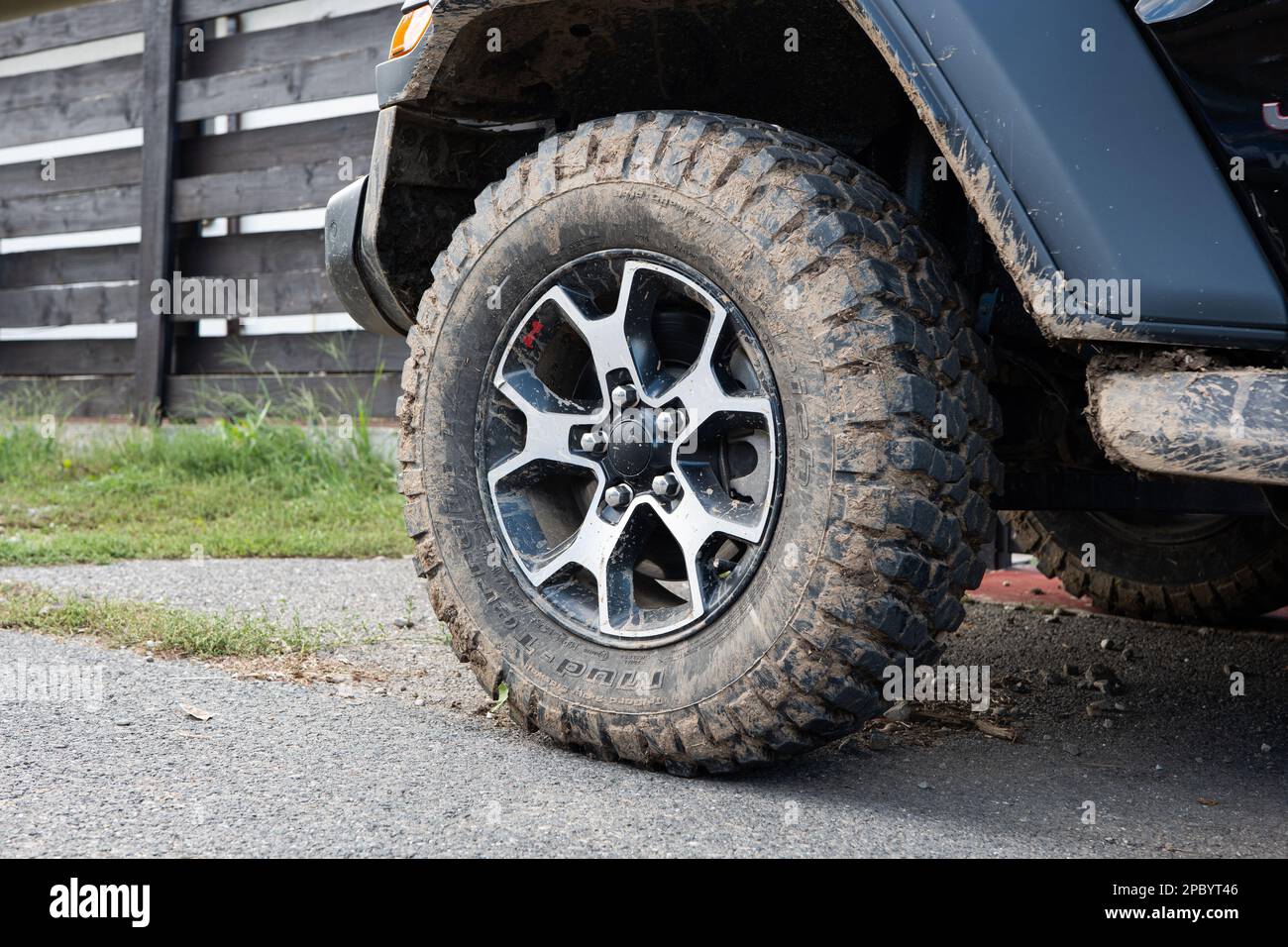 Fango secco sui pneumatici di fango fuoristrada del SUV. Primo piano, vista dall'angolo basso, nessuna persona. Foto Stock