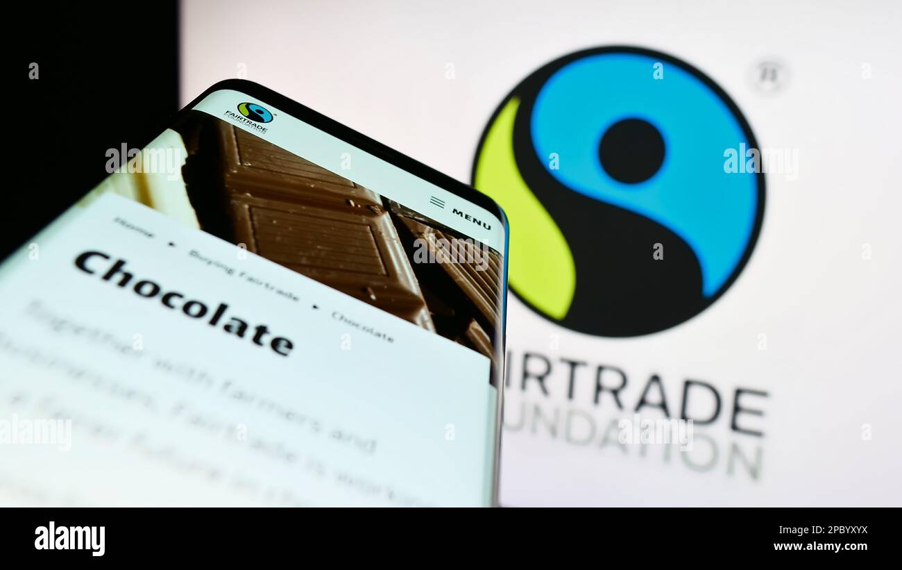 Telefono cellulare con pagina web dell'organizzazione benefica la Fairtrade Foundation sullo schermo davanti al logo. Messa a fuoco in alto a sinistra del display del telefono. Foto Stock