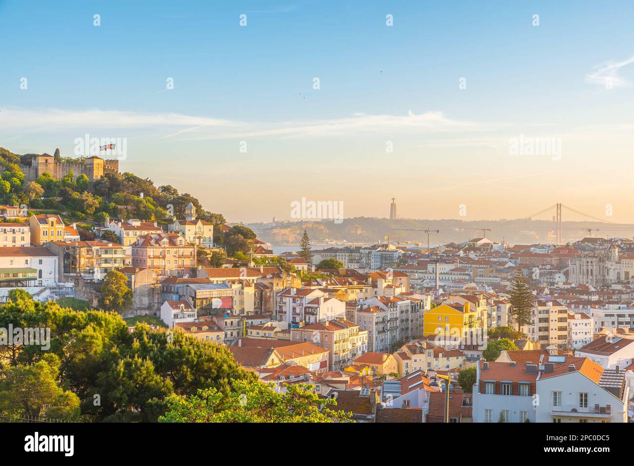 Vista al tramonto del centro storico di Lisbona sul fiume Tago con edifici medievali e castello. Lisboa, skyline del Portogallo. Destinazione del viaggio Foto Stock