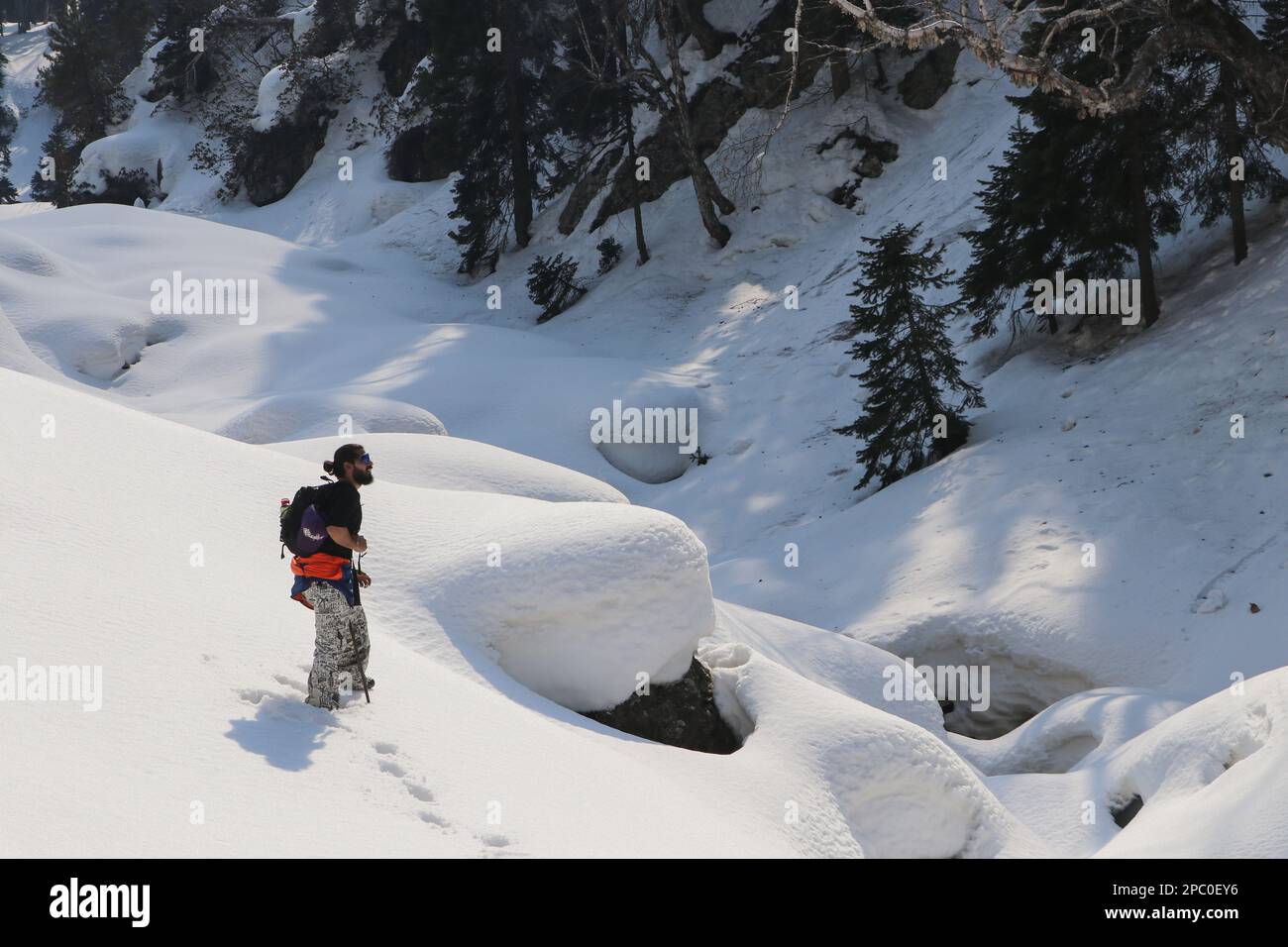 13 marzo 2023, Srinagar, Jammu e Kashmir, India: Un appassionato di natura si porta fino alla cima della collina innevata di Zabarwan, situata nella catena montuosa di Zabarwan a Srinagar. Questa catena montuosa si estende per un breve tratto di 32 km tra la catena montuosa del Pir Panjal e la Grande catena montuosa dell'Himalaya, nella parte centrale della Valle del Kashmir, Jammu e Kashmir. La vetta più alta di questa catena montuosa è Mahadev Peak, che torreggia a 13.013 piedi (3.966 m) e forma lo sfondo distante della parete di montagna orientale. (Credit Image: © Adel Abbas/ZUMA Press Wire) SOLO PER USO EDITORIALE! Non per USO commerciale! Foto Stock