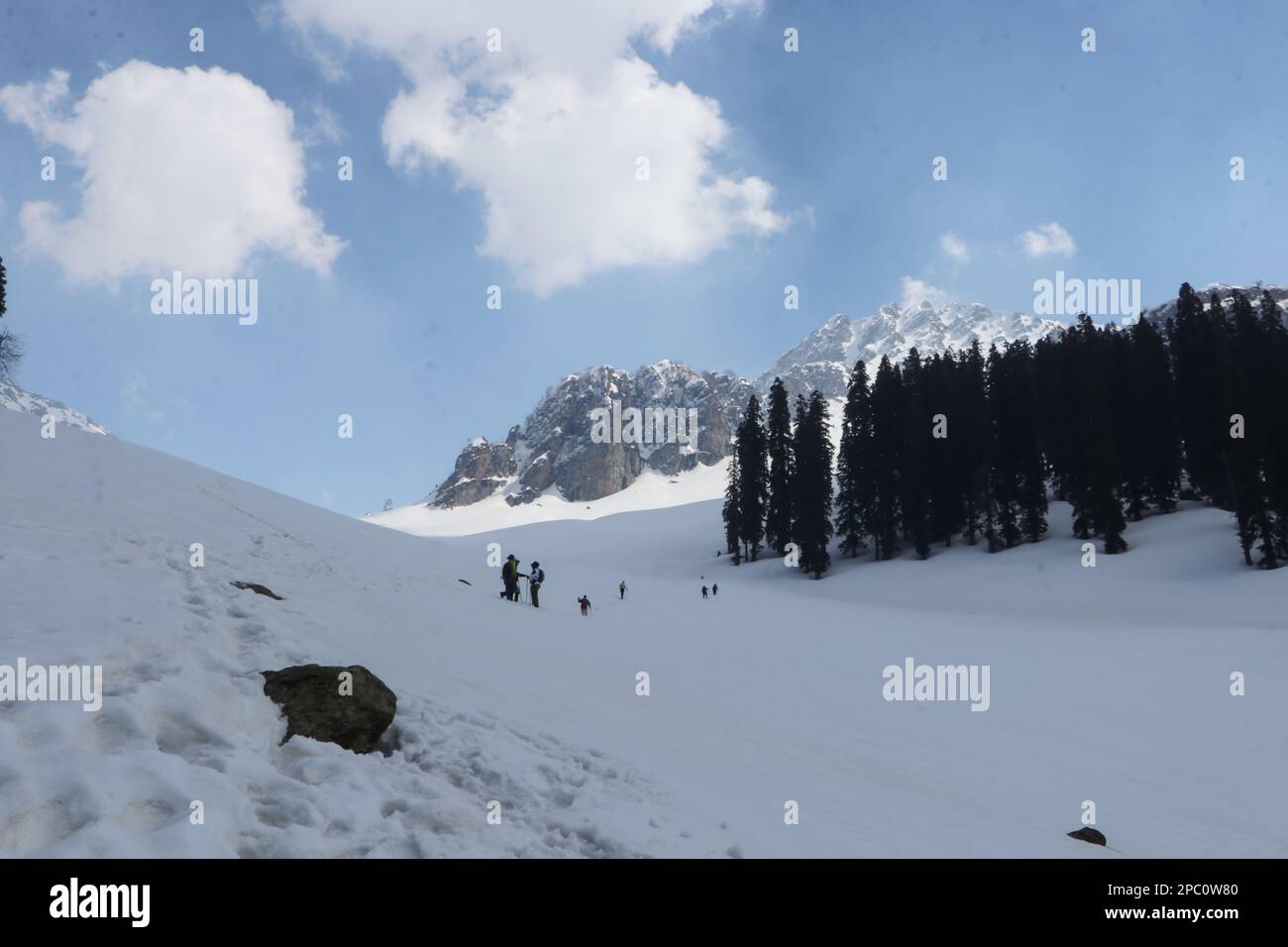 13 marzo 2023, Srinagar, Jammu e Kashmir, India: Gli escursionisti e gli appassionati della natura stanno facendo la loro strada fino alla cima della collina coperta di neve di Zabarwan, situata nella catena montuosa di Zabarwan a Srinagar. Questa catena montuosa si estende per un breve tratto di 32 km tra la catena montuosa del Pir Panjal e la Grande catena montuosa dell'Himalaya, nella parte centrale della Valle del Kashmir, Jammu e Kashmir. La vetta più alta di questa catena montuosa è Mahadev Peak, che torreggia a 13.013 piedi (3.966 m) e forma lo sfondo distante della parete di montagna orientale. (Credit Image: © Adel Abbas/ZUMA Press Wire) SOLO PER USO EDITORIALE! Non per Foto Stock