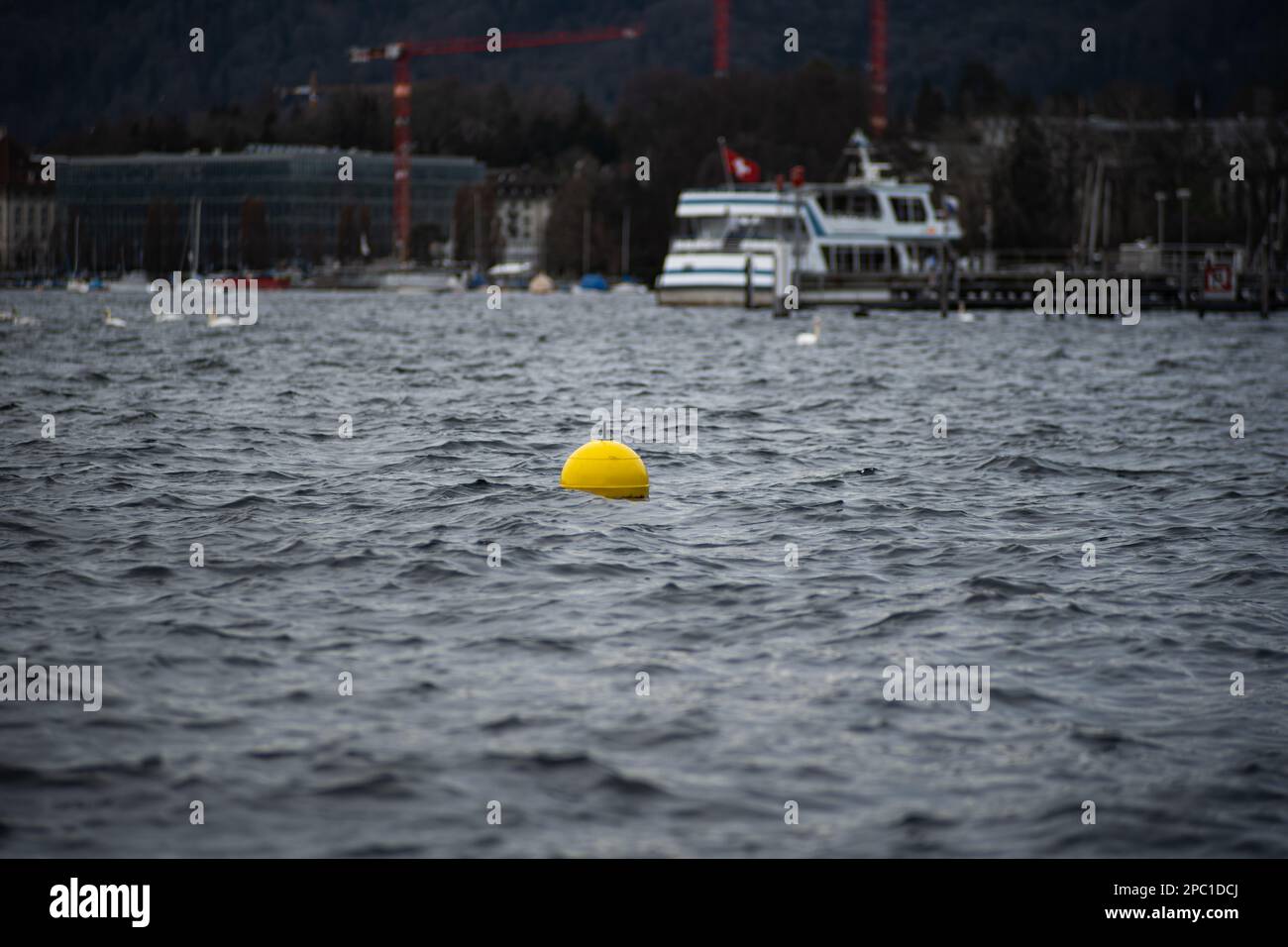 Boa di plastica gialla o boe galleggianti sull'acqua di un lago in Svizzera, Europa. Teleobiettivo per primo piano, nessuna persona Foto Stock