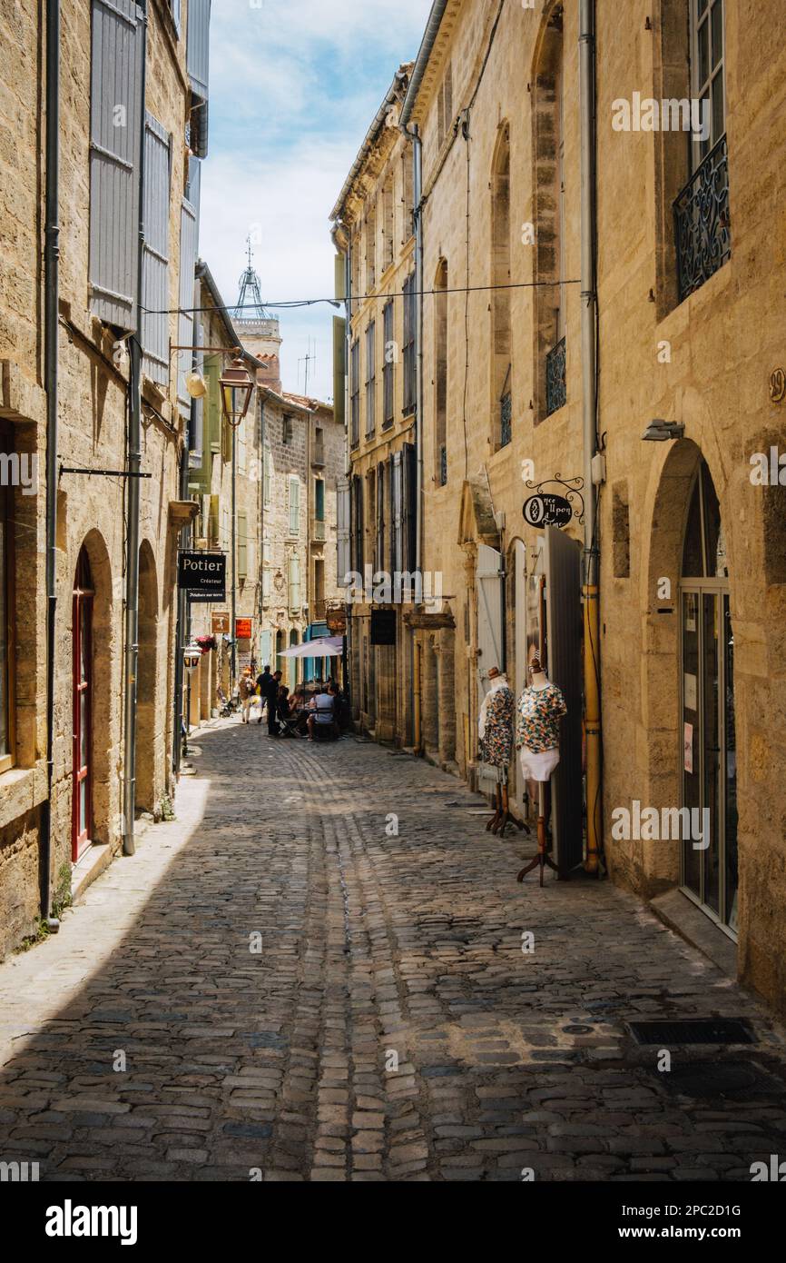 Pittoreschi negozi e facciate sulla strada lastricata di ciottoli di Rue de la foire, nel centro storico medievale di Pezenas, nel sud della Francia (Herault). Foto Stock