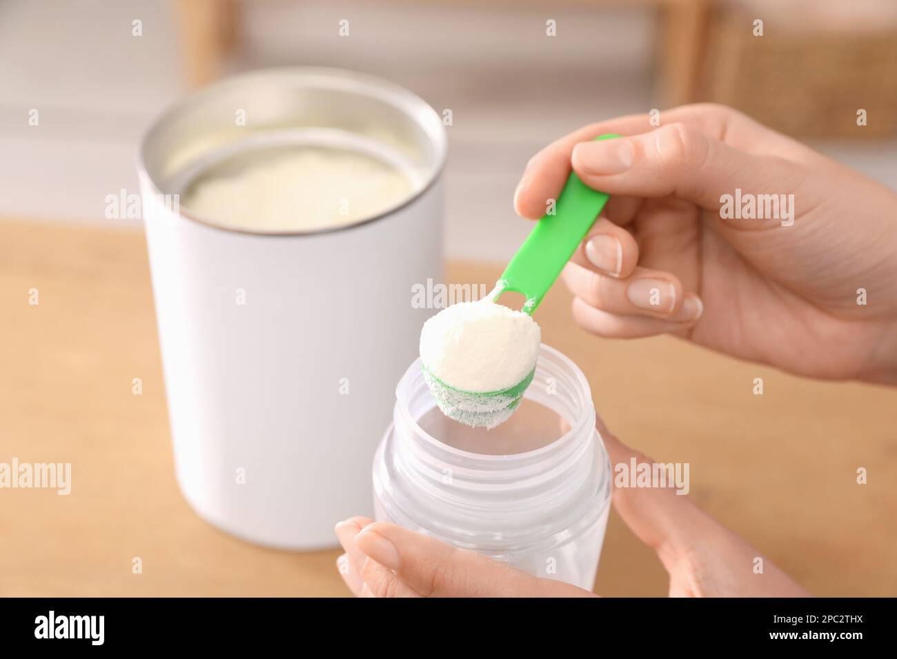 Donna che prepara latte in polvere per neonati a tavola al chiuso, primo  piano. Latte per bambini Foto stock - Alamy