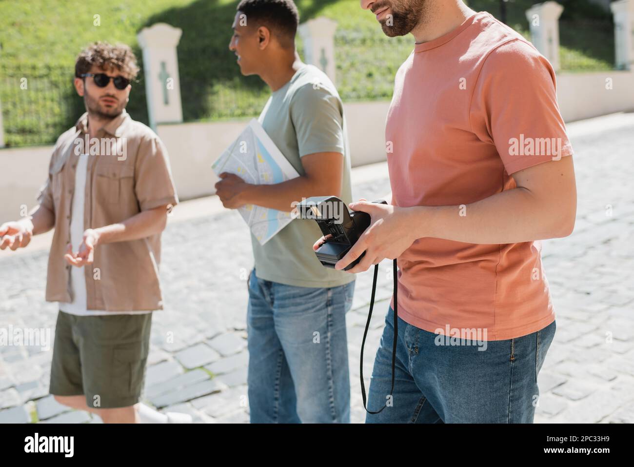 Guida del tour sfocata che gestura e parla con i turisti interrazziali durante la passeggiata nel quartiere di Podil a Kiev, immagine di scorta Foto Stock