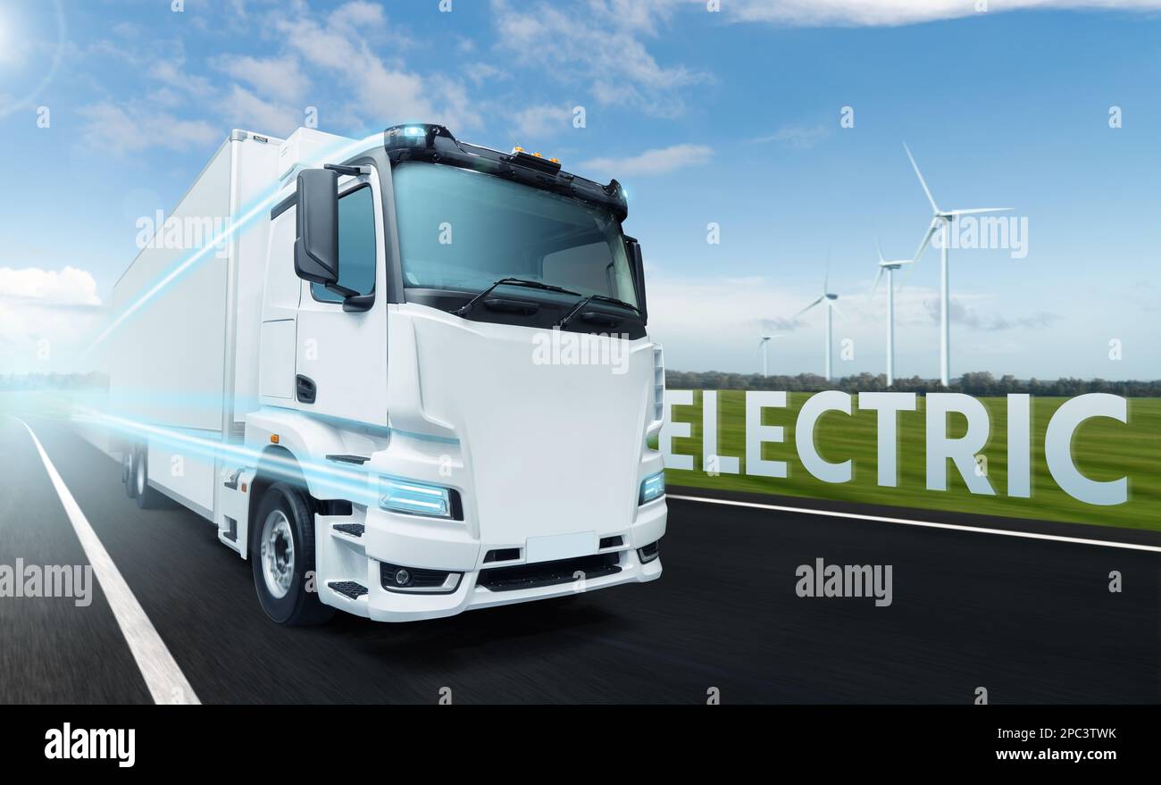 Concetto di autocarro elettrico bianco su strada con turbine eoliche all'orizzonte Foto Stock