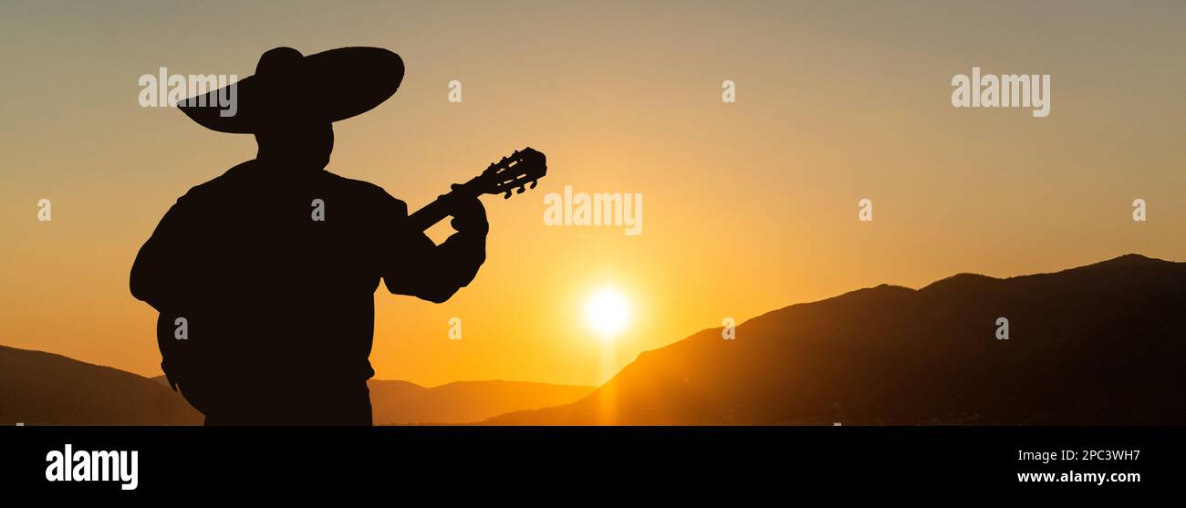 Silhouette di un musicista messicano mariachi con una chitarra sullo sfondo del panorama della città. Foto Stock