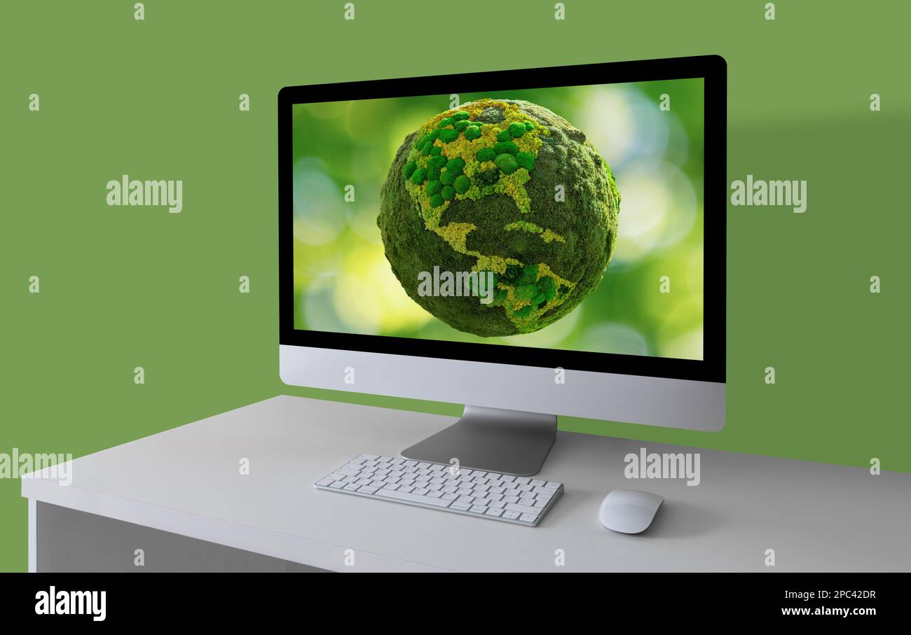 Computer con pianeta Terra verde su uno schermo Foto Stock