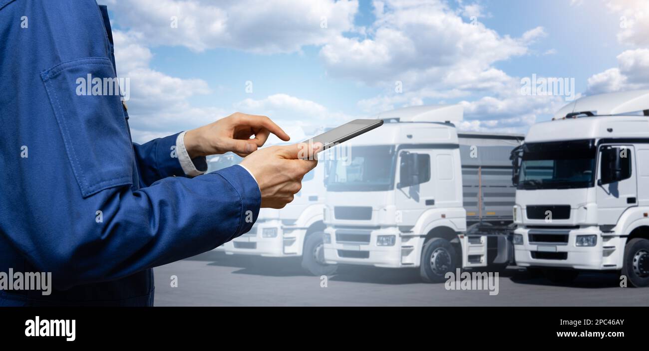 Manager con un tablet digitale accanto ai veicoli. Gestione della flotta Foto Stock