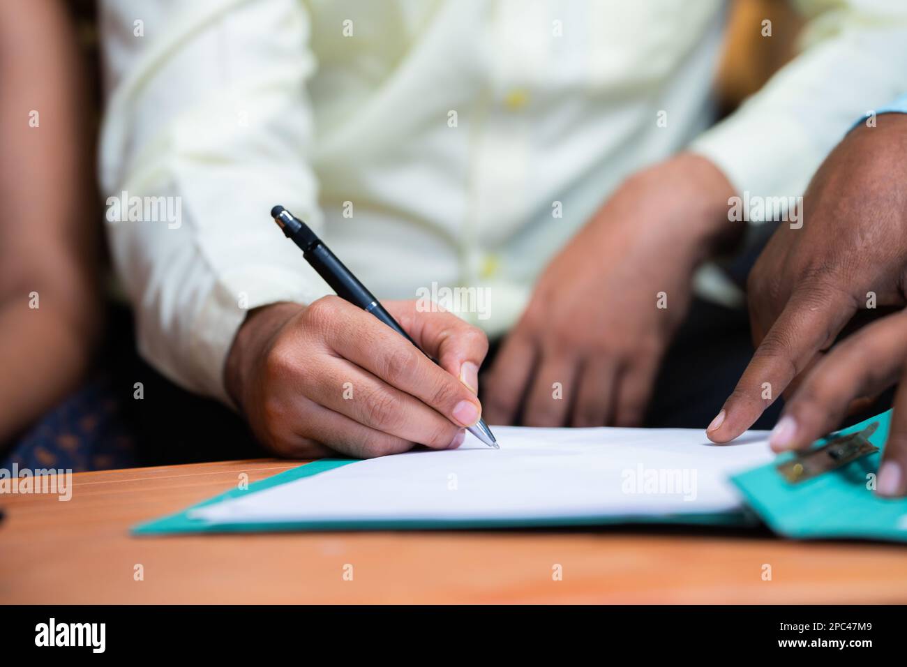 Primo piano ripresa del funzionario bancario che prende il segno dal padre per i documenti di prestito a casa - concetto di sostegno finanziario, assicurazione e banche Foto Stock