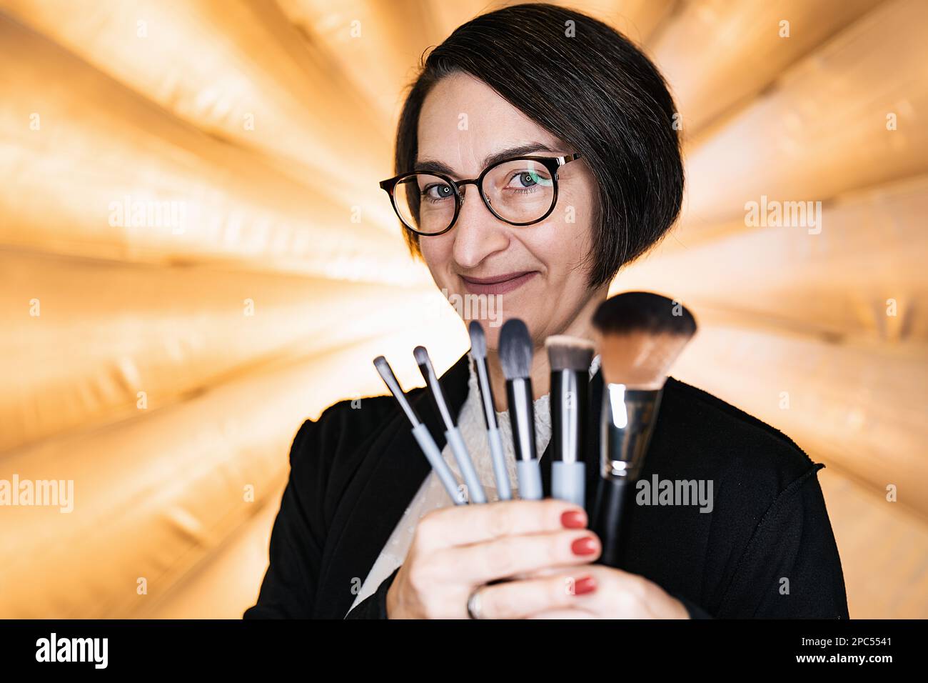 Makeup artista che tiene un set di pennelli per il trucco presso un photostudio Foto Stock