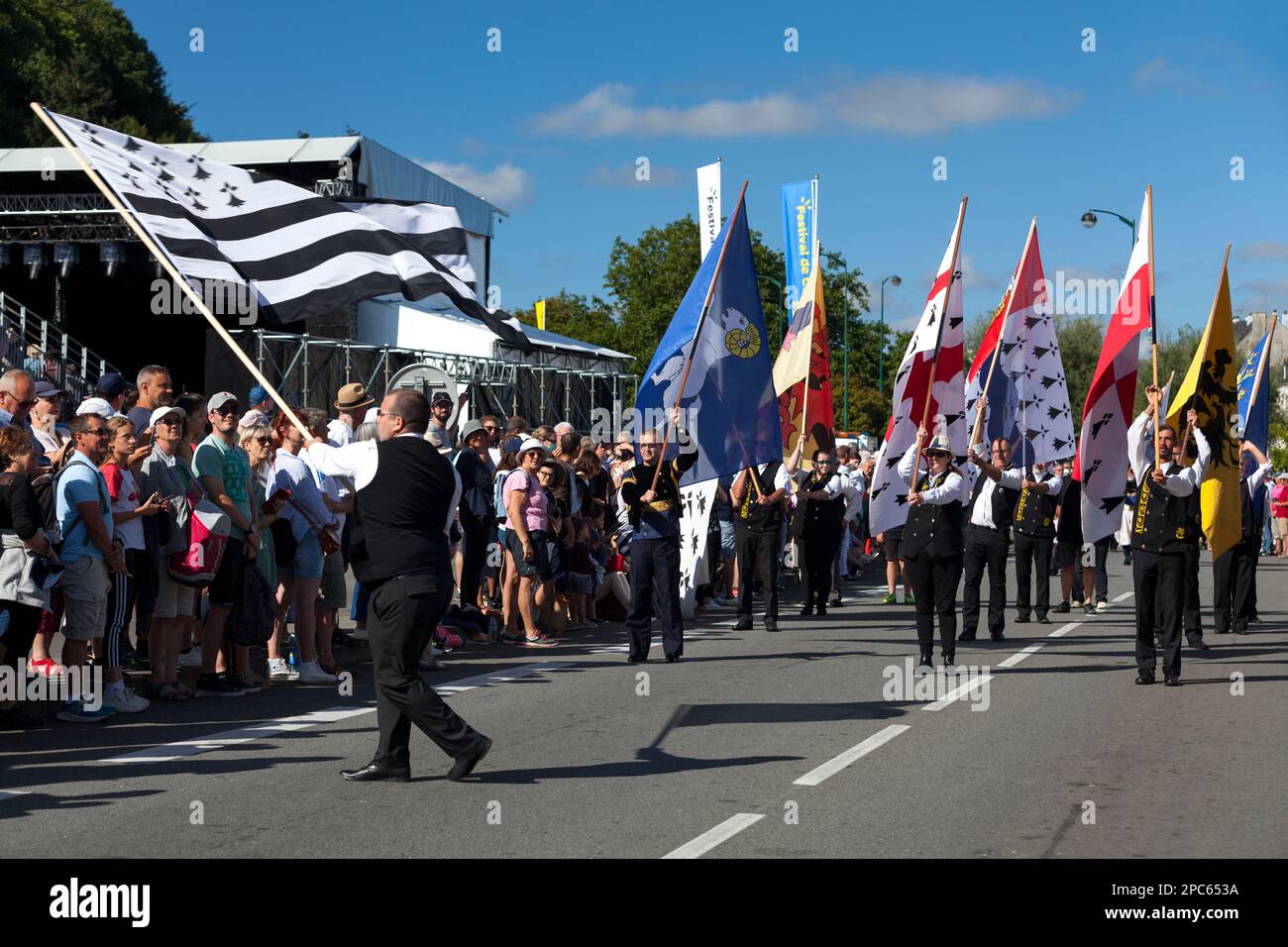 Quimper, Francia - 24 2022 luglio: I portatori di bandiera che presentano i diversi banner dei paesi bretoni durante il festival Cornouaille. Foto Stock