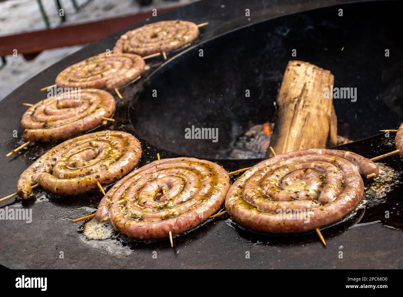 Salsicce arrotolate a spirale preparate con carne macinata alla griglia o arrostite in un barbecue sul fuoco aperto Foto Stock