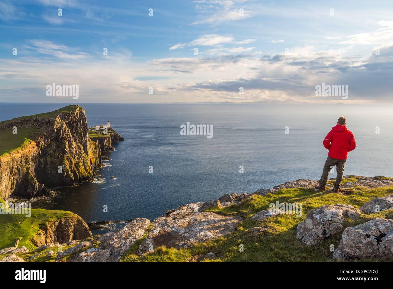 Uomo ammirando la vista, faro, Neist Point, Isola di Skye, Highland Region, Scozia Foto Stock