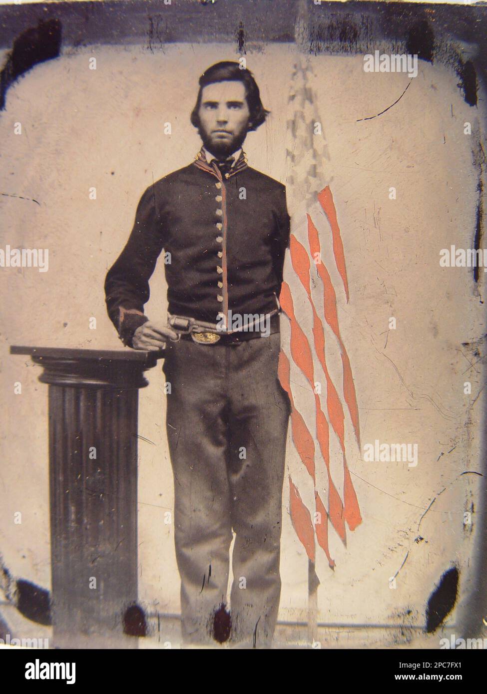 Soldato non identificato nell'uniforme dell'artiglieria dell'Unione che si trova accanto al revolver di supporto del piedistallo e alla bandiera americana. Liljenquist Family Collection of Civil War Photographs , ha esposto: 'The Last Full Measure : Civil War Photographs from the Liljenquist Family Collection' alla Library of Congress, Washington, D.C, 2011, pp/liljunion. Stati Uniti, Esercito, persone, 1860-1870, soldati, Unione, 1860-1870, pistole, 1860-1870, uniformi militari, Union, 1860-1870, Flags, americano, 1860-1870, Stati Uniti, Storia, Guerra civile, 1861-1865, personale militare, Unione. Foto Stock