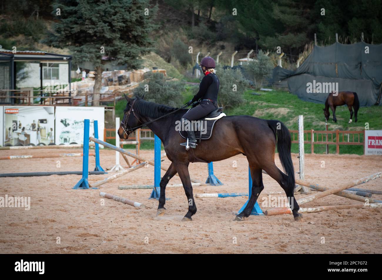 Immagini stupefacenti delle donne che cavalcano cavalli per saltare sopra gli ostacoli. Donna che salta nel maneggio con un cavallo. Foto Stock