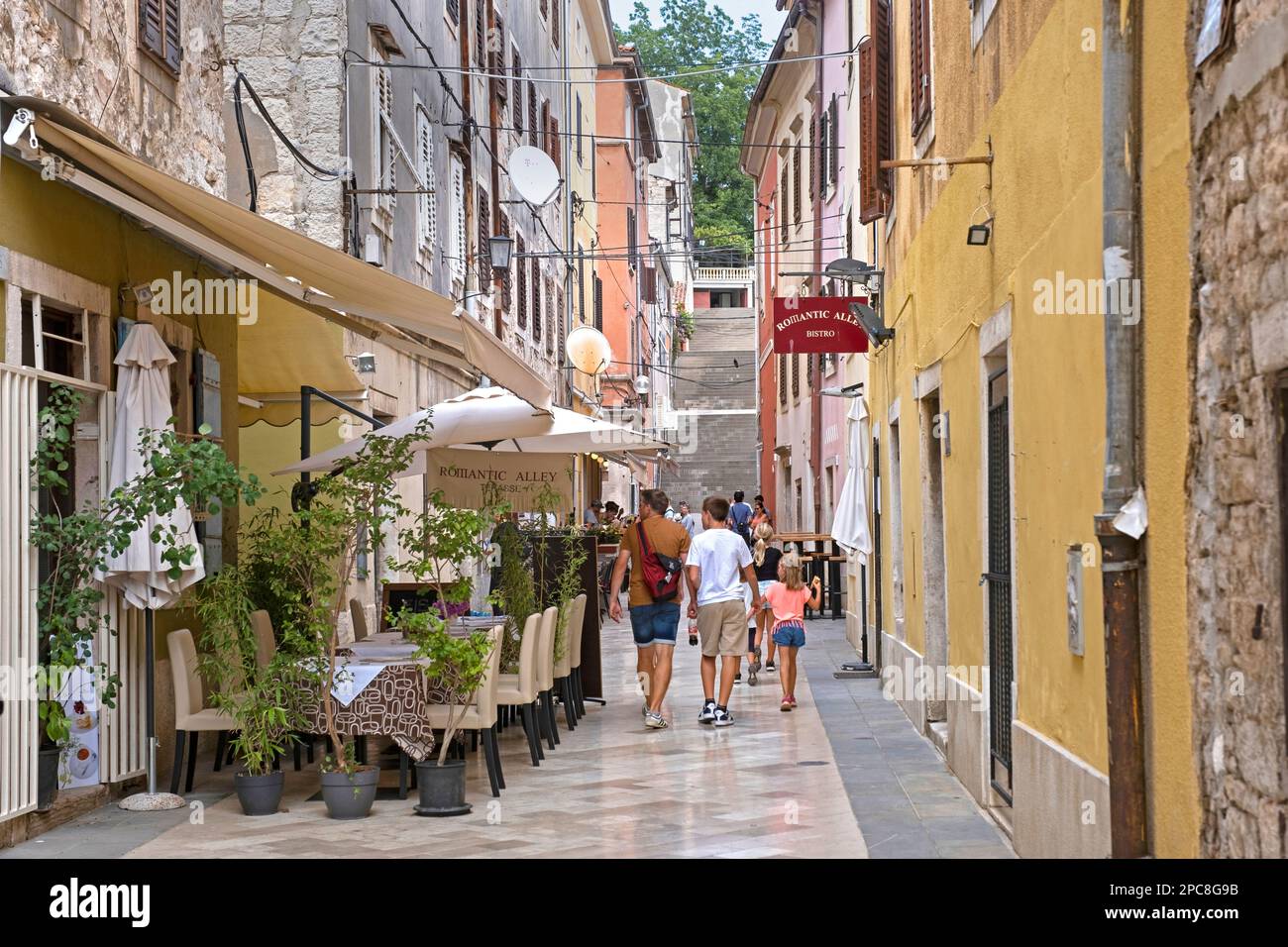 Turisti che camminano in vicolo con ristoranti nel centro storico della città di Pola / Pola, Istria County, Croazia Foto Stock