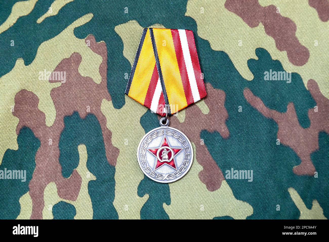 Mosca, Russia - 13 marzo 2023: Medaglia al partecipante dell'operazione militare Speciale su sfondo mimetico. Premio del Ministero della Difesa Foto Stock
