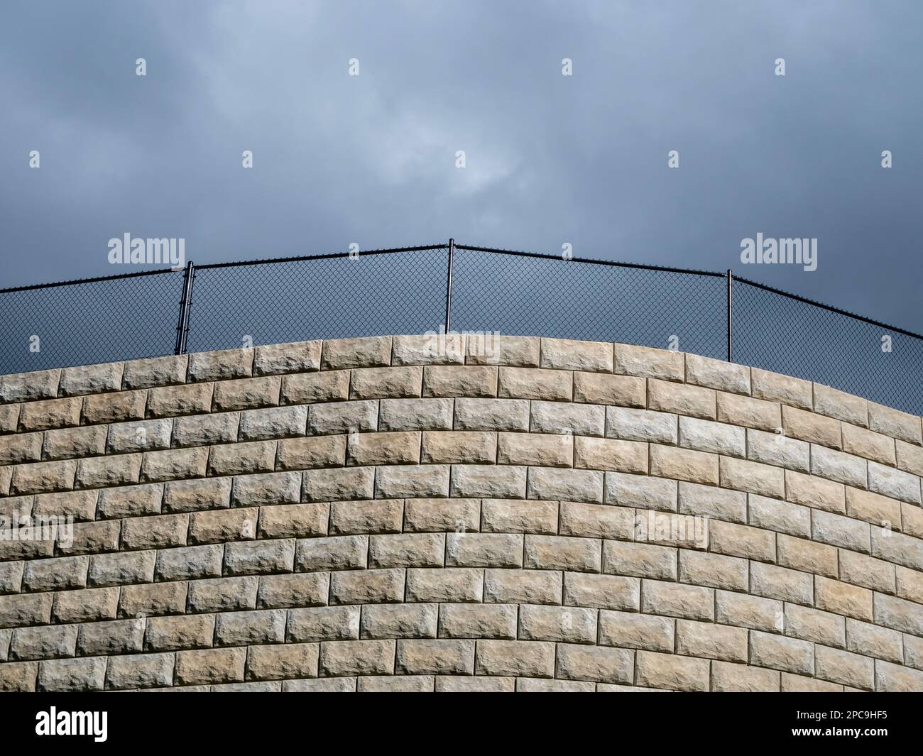 WA23246-00...WASHINGTON - mattoni di paesaggio che formano una parete sormontata da una recinzione di maglia di catena. Foto Stock