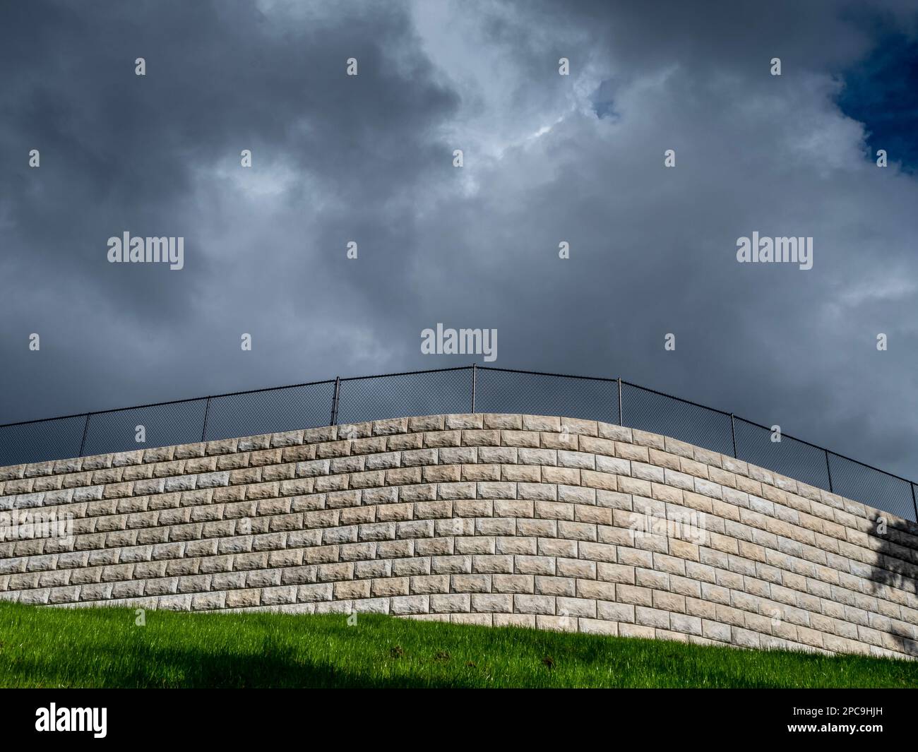 WA23247-00...WASHINGTON - Paesaggio mattoni che formano un muro sormontato da una catena di collegamento recinzione visto dal Mukilteo Trails e Tails Park. Foto Stock